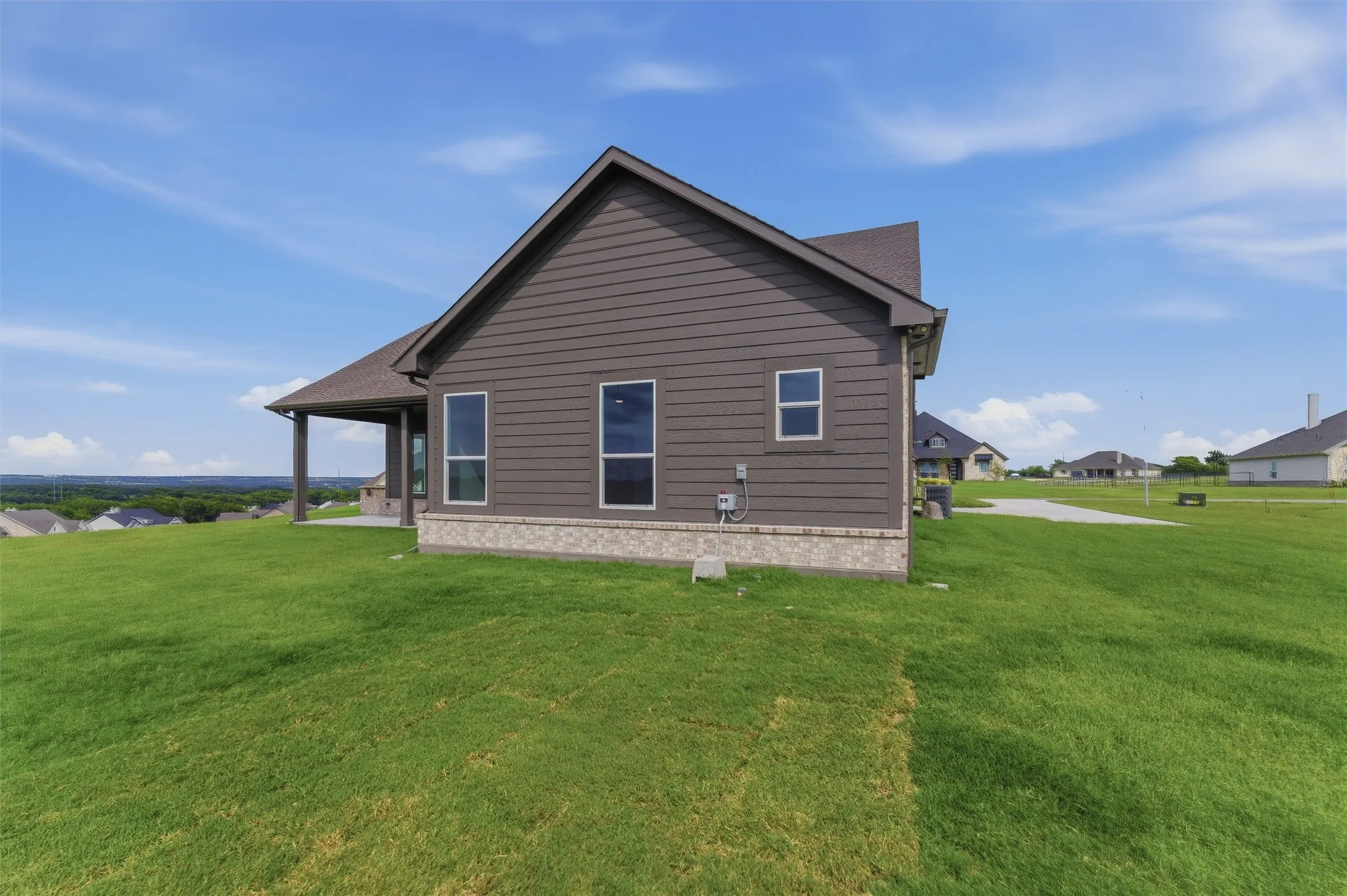 Exterior siding in a neutral tone with a contrasting stone base