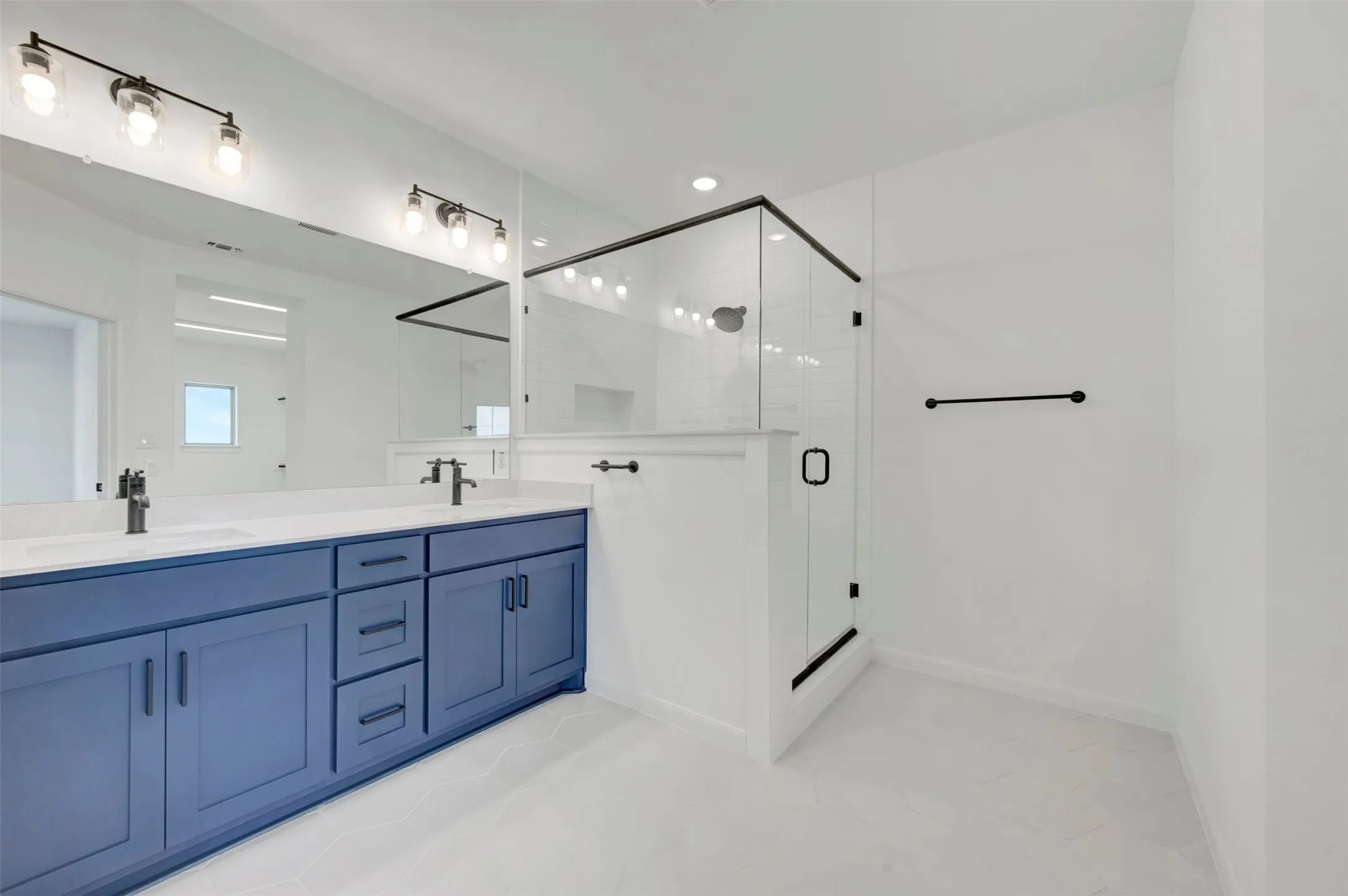 Bathroom featuring a dual vanity with blue cabinetry, white countertops, dual undermount sinks, and matte black faucets