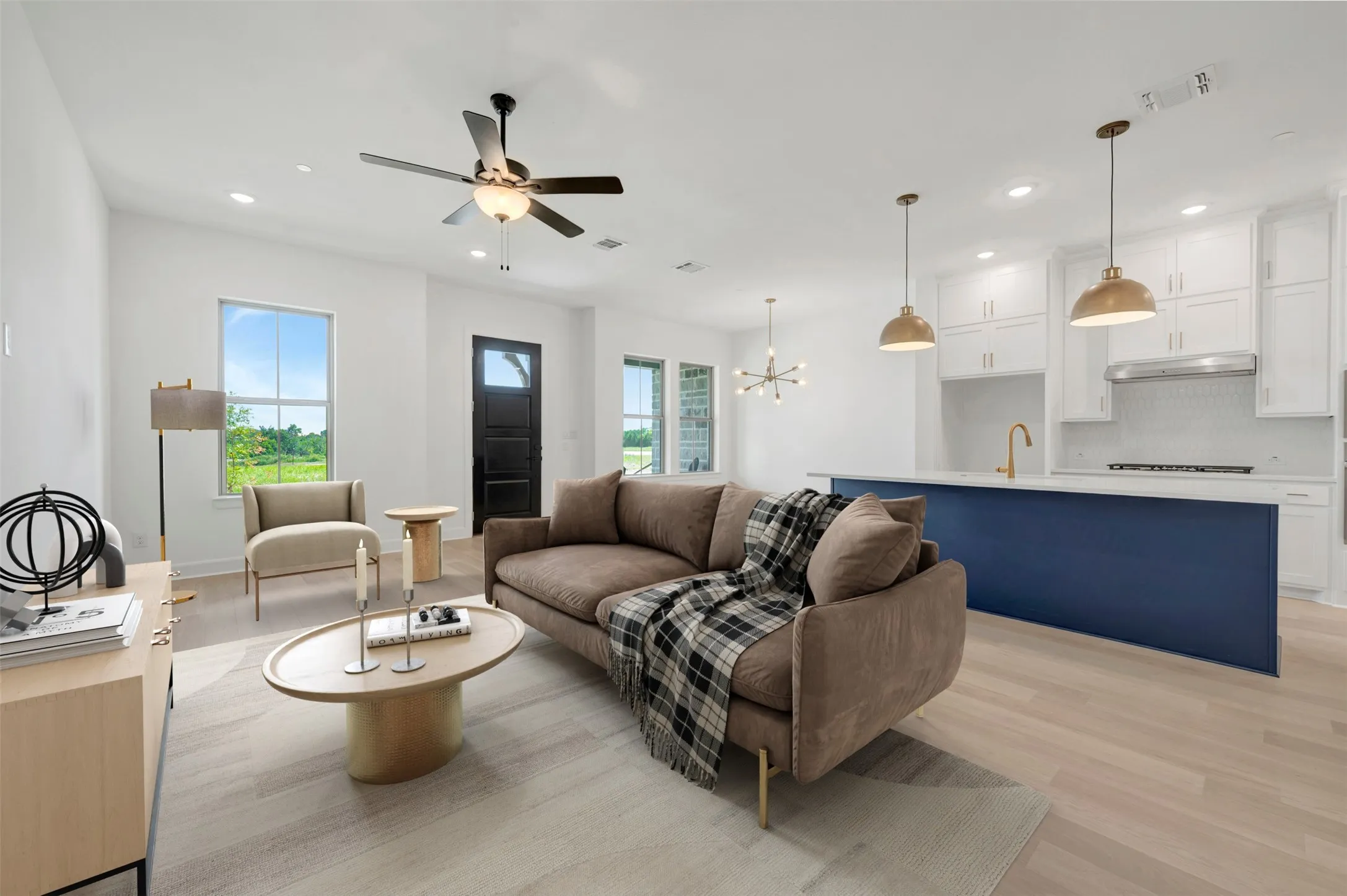 Open-concept living space featuring light wood-finish flooring, recessed lighting, and a contemporary ceiling fan