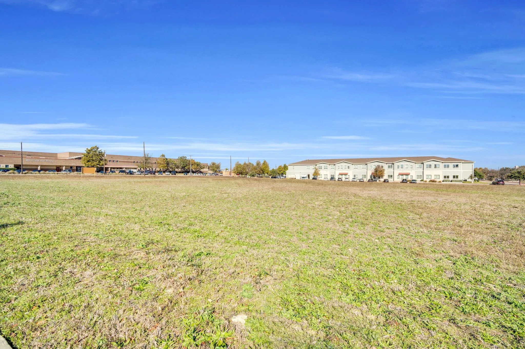 Ground view of the property, offering a closer look at the surrounding growth and development.