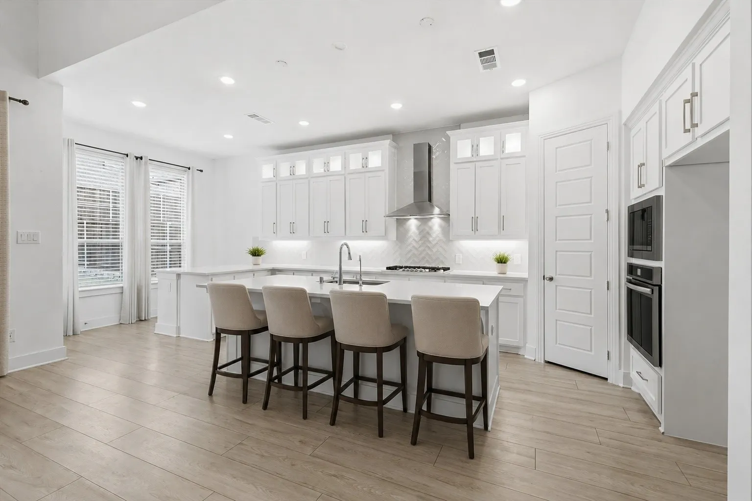 Marvelous Kitchen with white cabinets, SS appliacnes, Gas Cooktop, Decorative cabinets and massive amounts of counter space with island and additional seating on peninsula *virtually staged