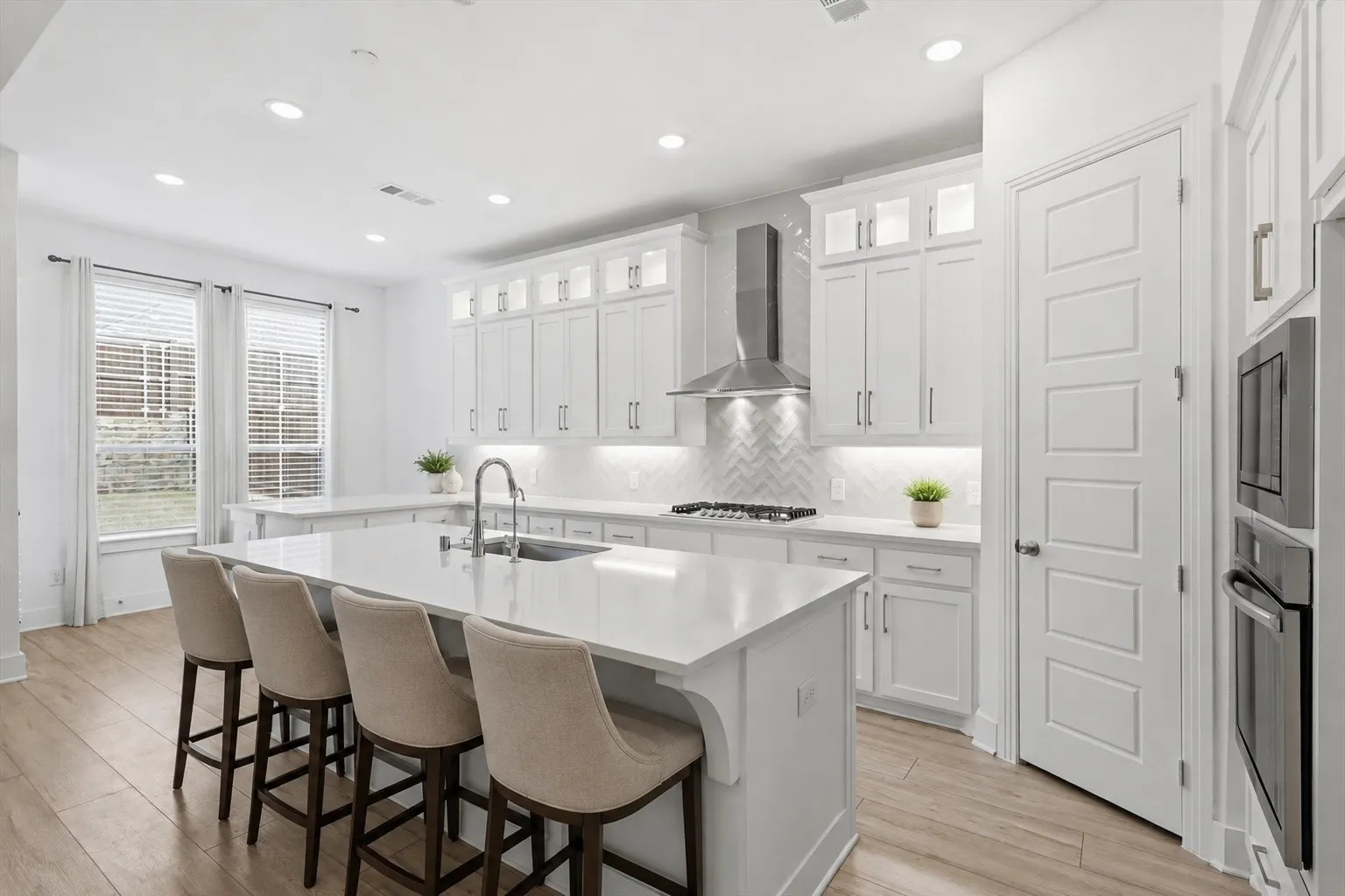 Marvelous Kitchen with white cabinets, SS appliacnes, Gas Cooktop, Decorative cabinets and massive amounts of counter space with island and additional seating on peninsula *virtually staged