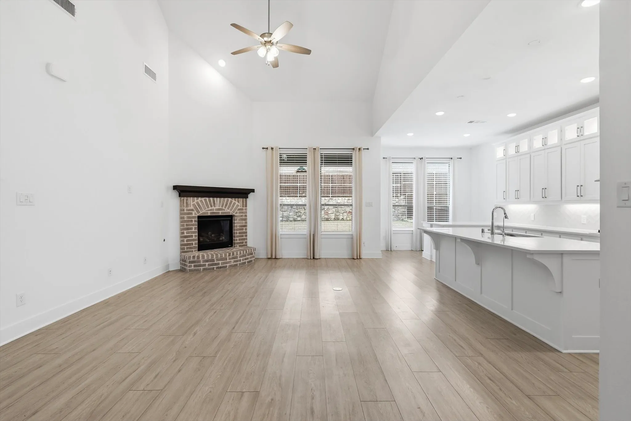 LVP Flooring, White Cabinets with glass uppers for decorating, Gas fireplace in living and tons of natural lighting