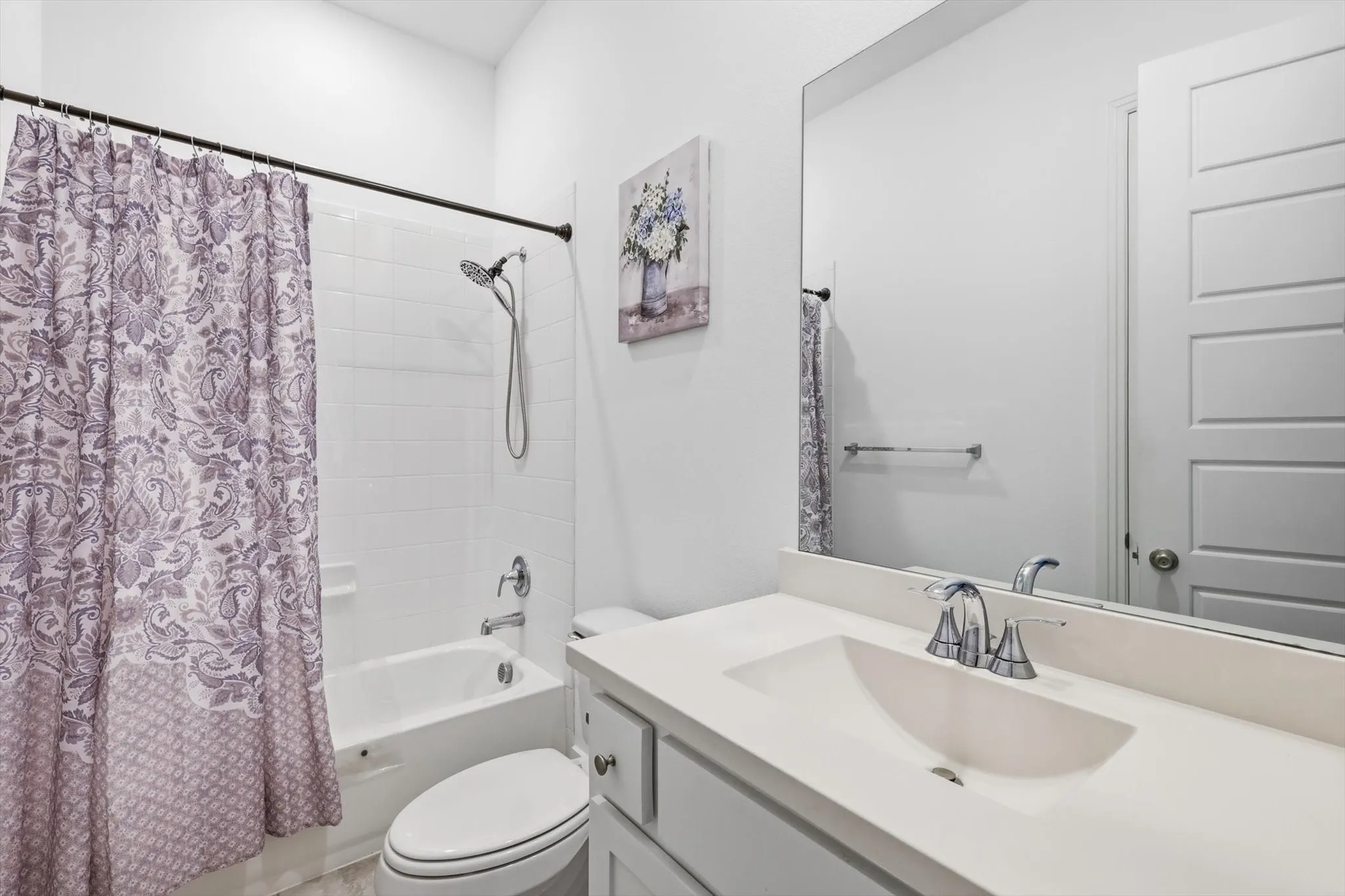 Bathroom featuring vanity and shower / bathtub combination with curtain