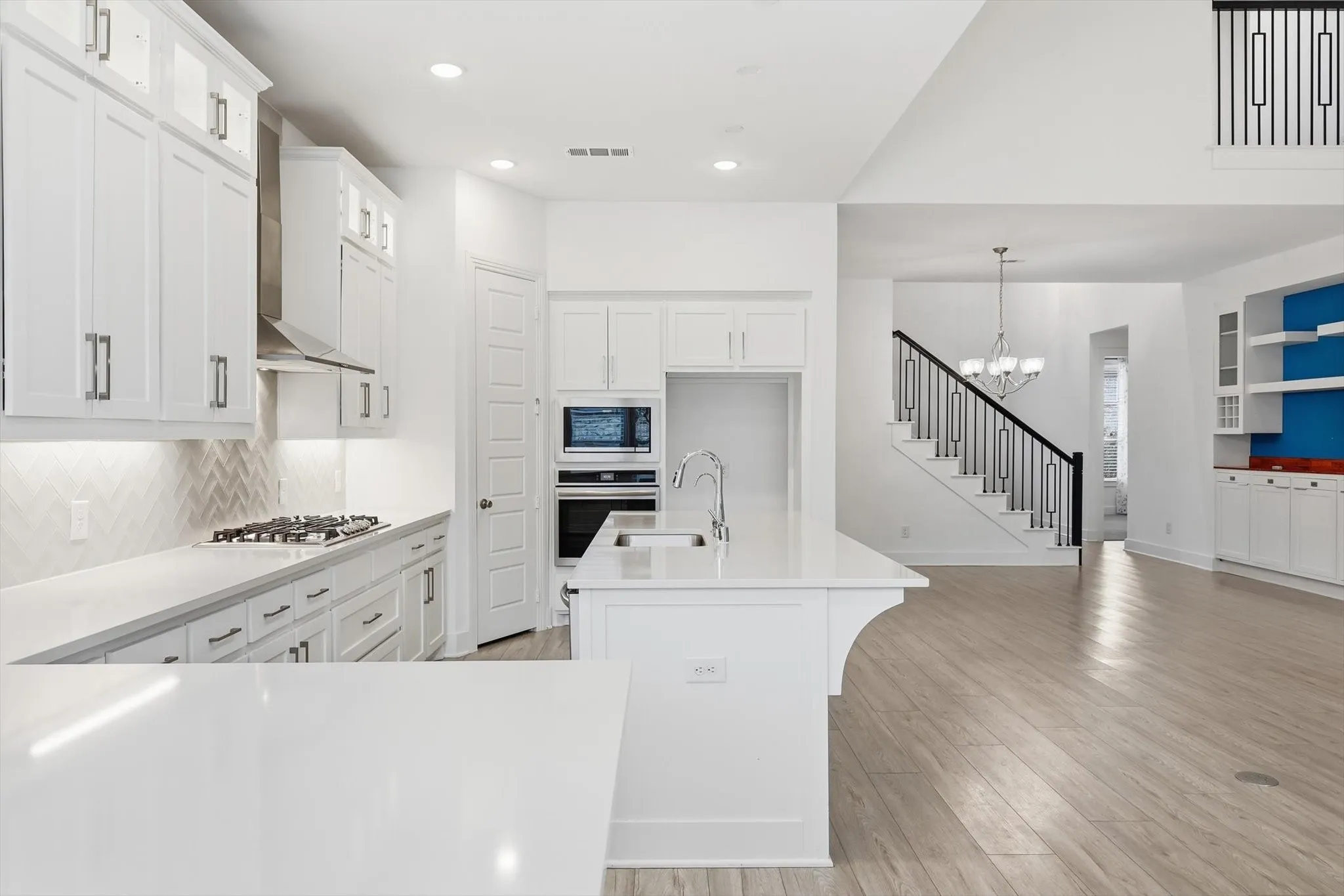 Marvelous Kitchen with white cabinets, SS appliacnes, Gas Cooktop, Decorative cabinets and massive amounts of counter space with island and additional seating on peninsula