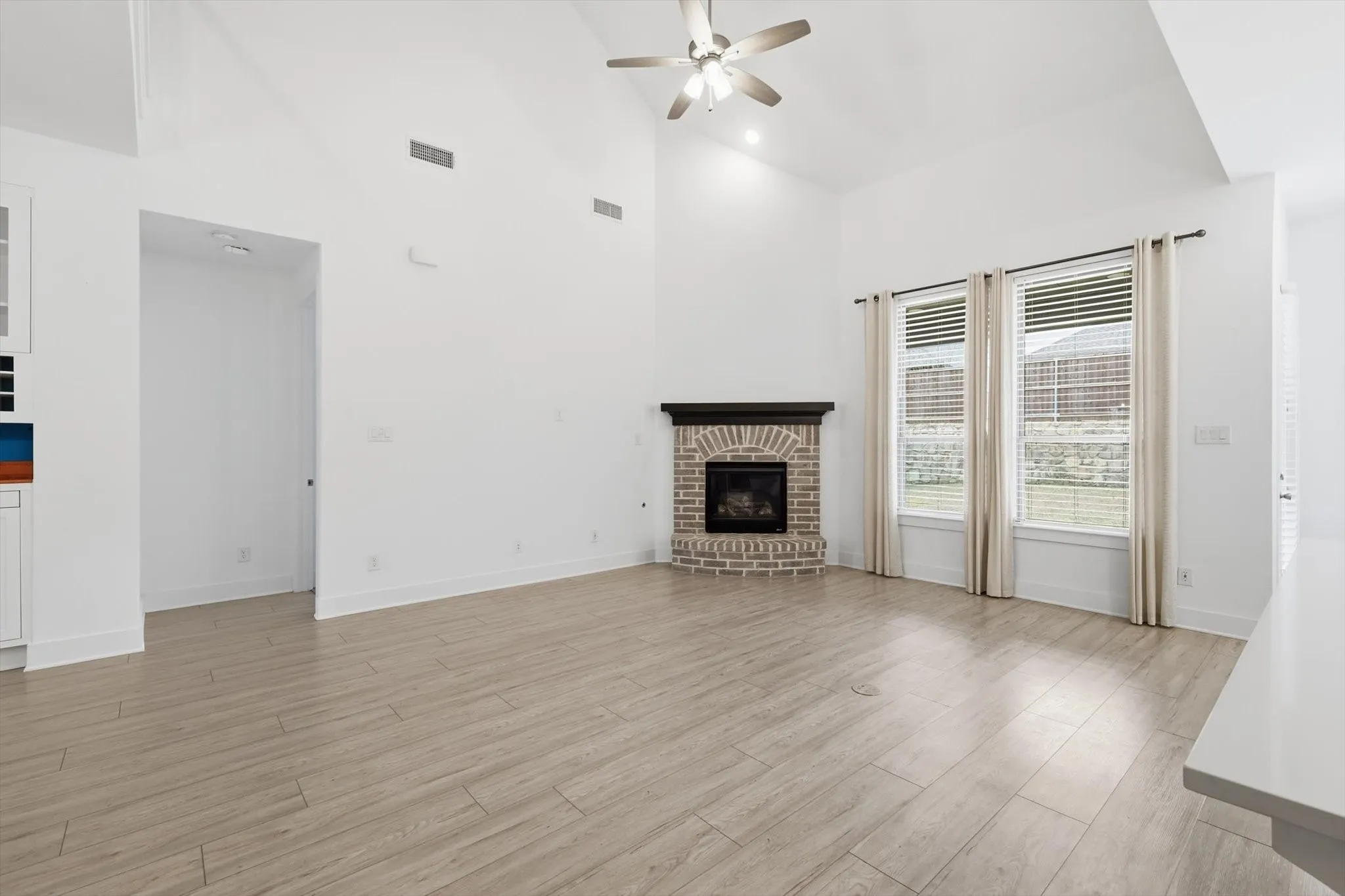 LVP Flooring, White Cabinets with glass uppers for decorating, Gas fireplace in living and tons of natural lighting