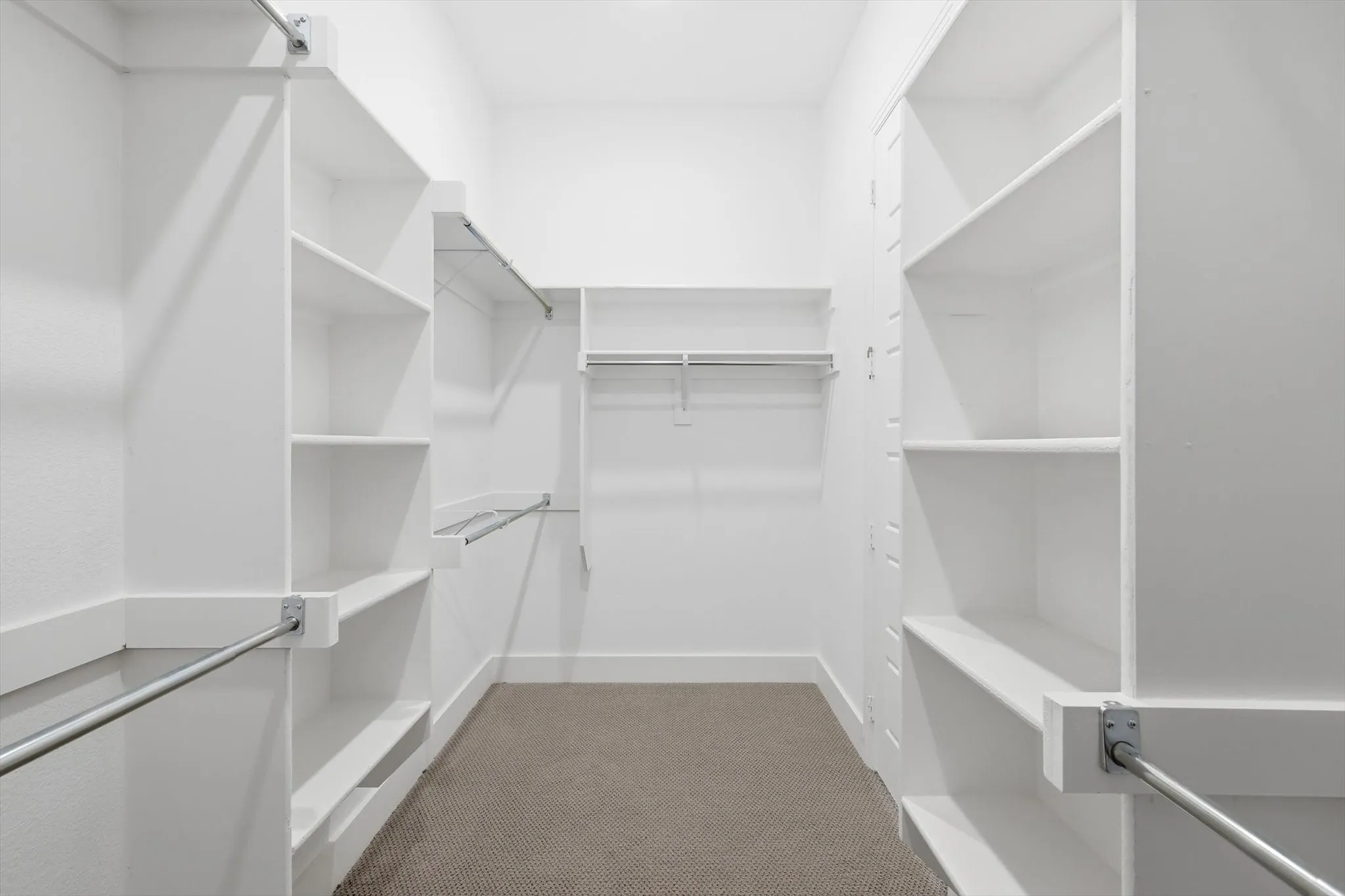 Primary Closet with built in shelving, wrapped around with storage