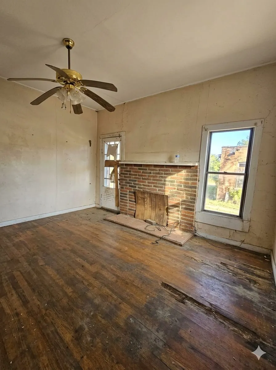  Living room with dark wood-type flooring, a ceiling fan, and a fireplace