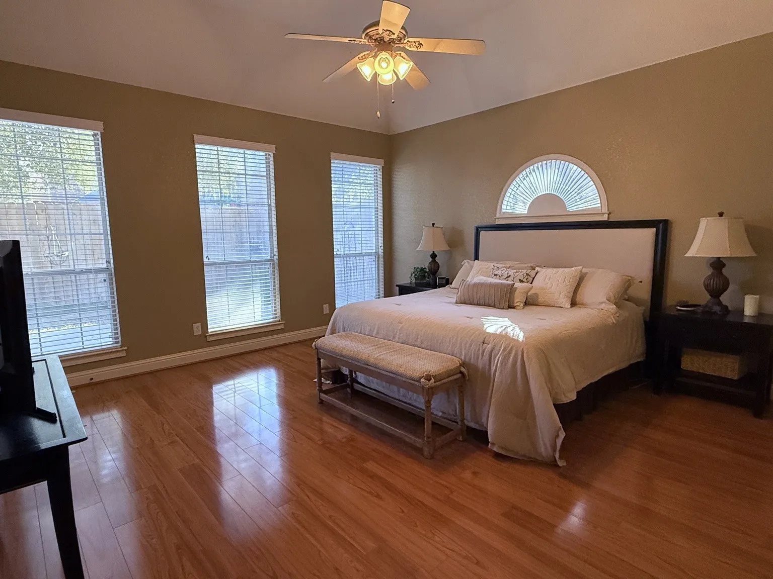 Spacious room with warm-toned wood-finish flooring
