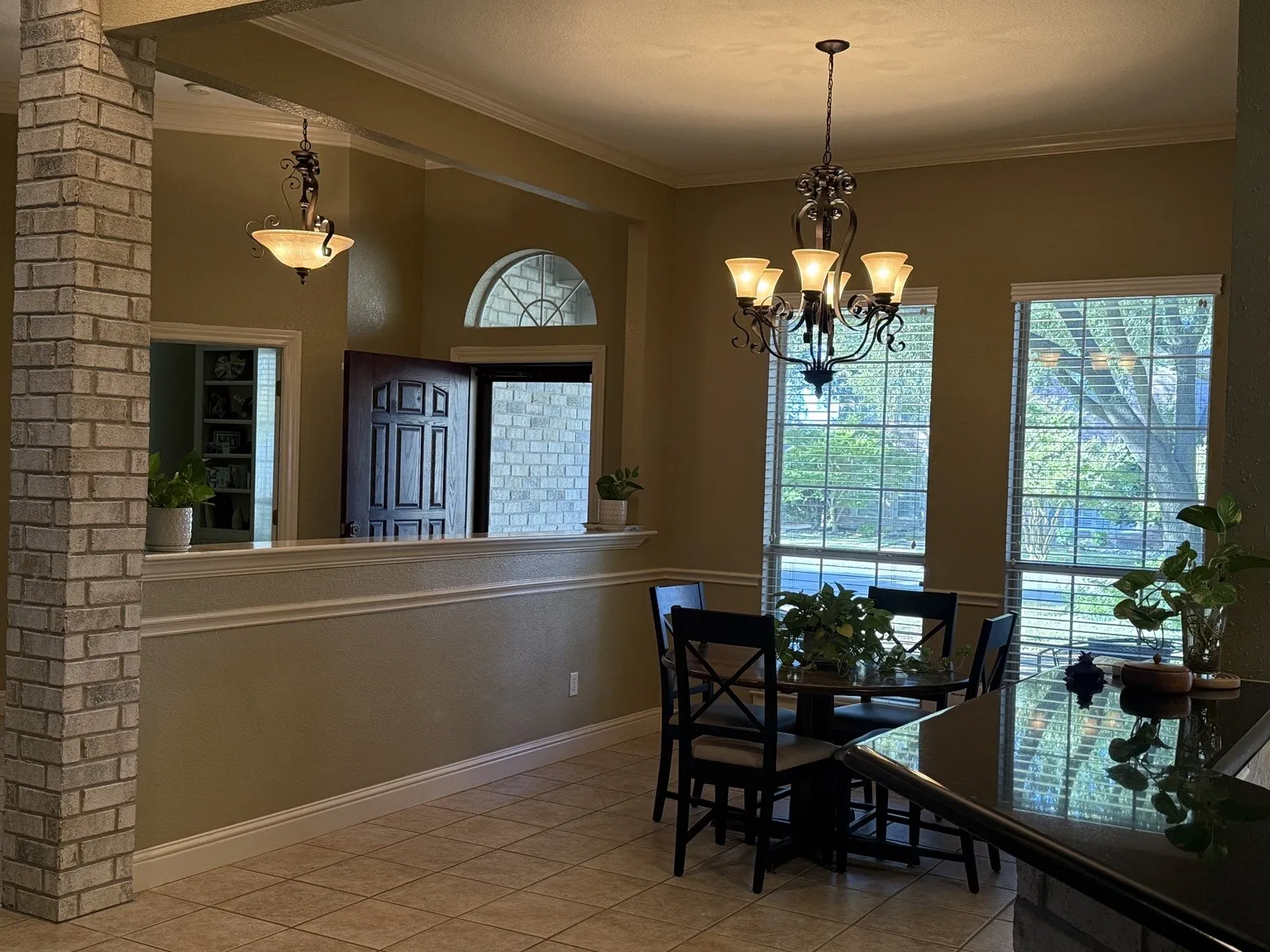 Open-concept living area with tile flooring and crown molding