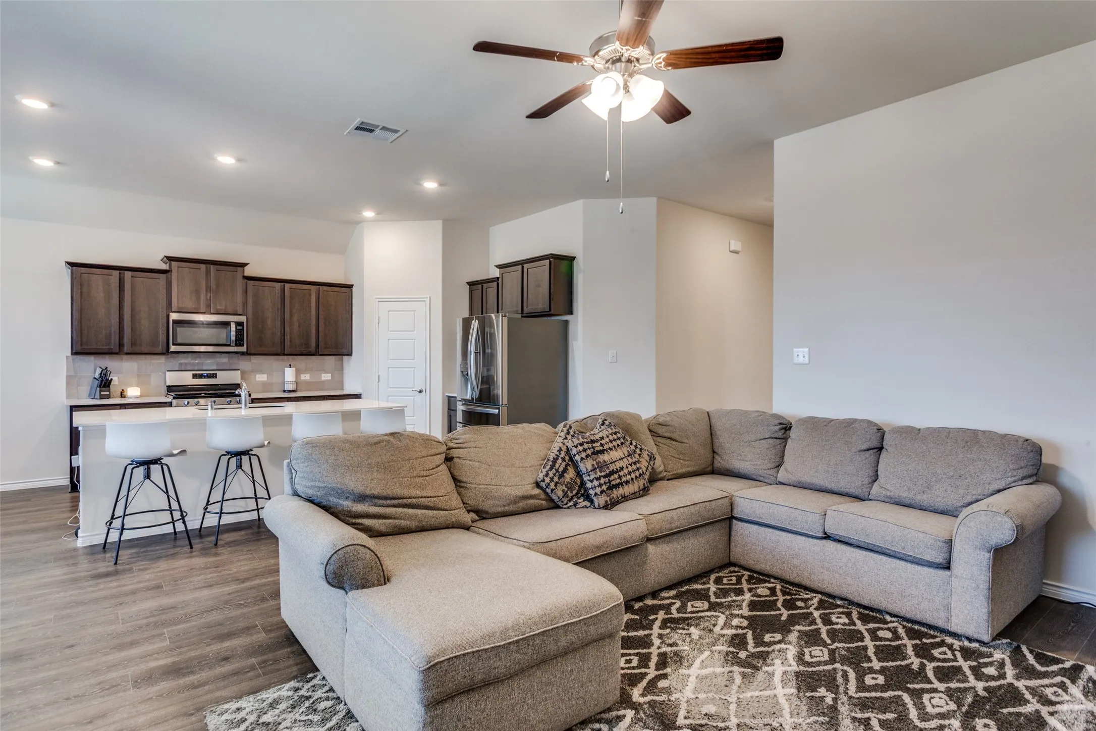 Living room featuring a ceiling fan, light wood-style floors, and recessed lighting