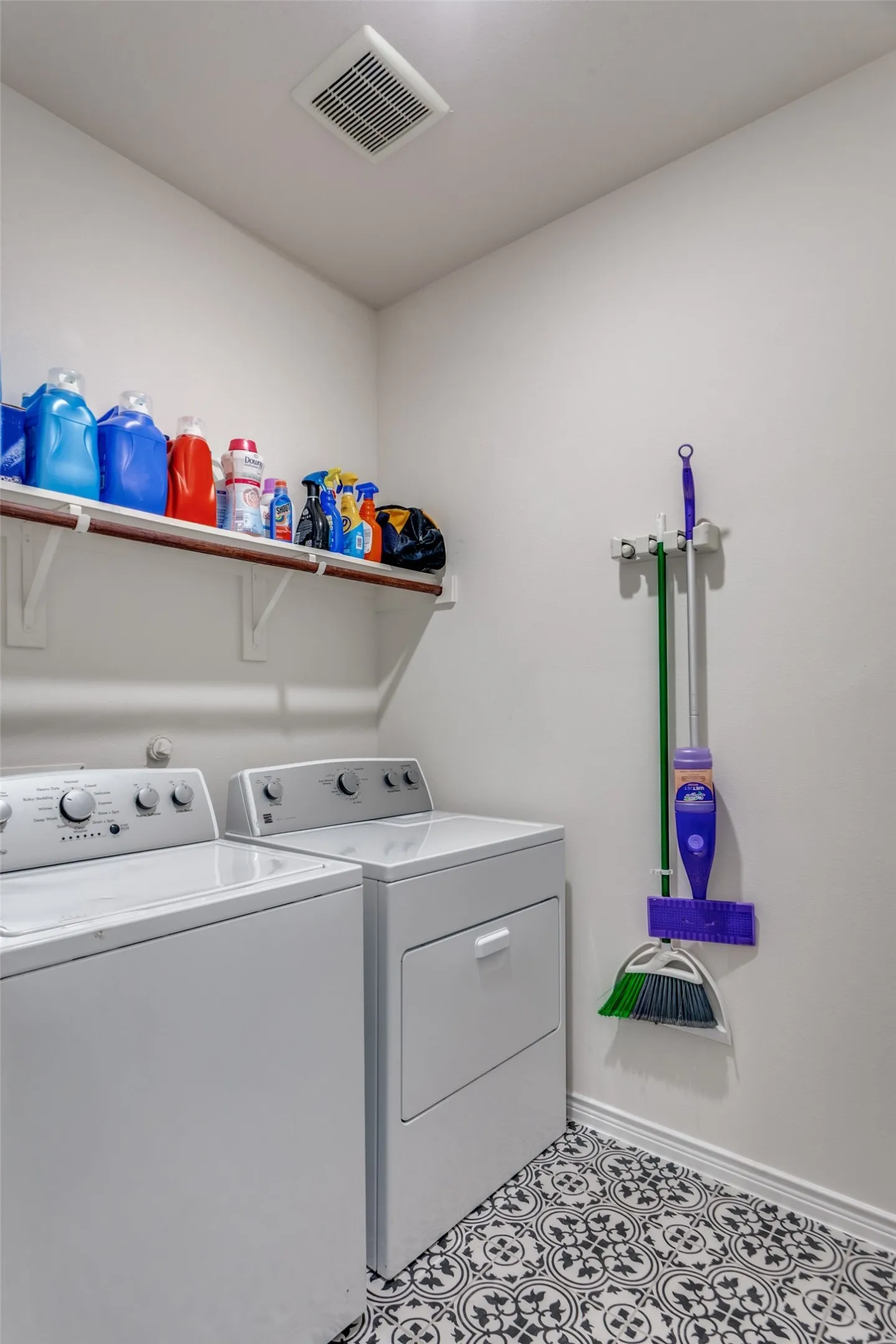 Laundry area featuring washer and clothes dryer and light tile patterned flooring