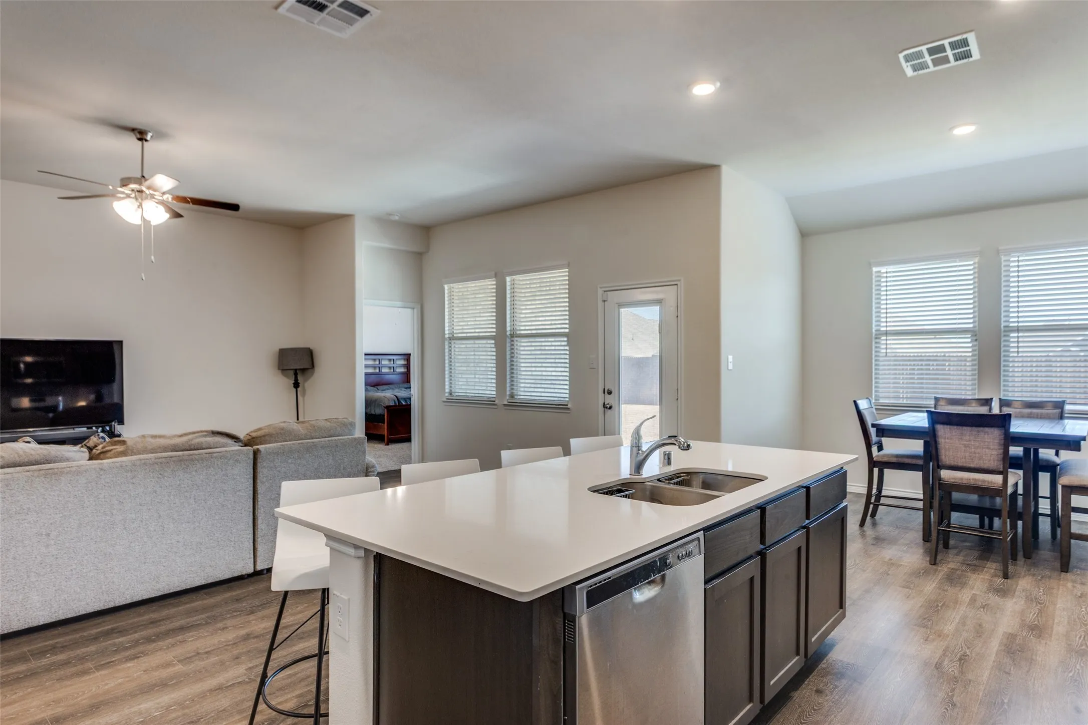 Kitchen with a kitchen bar, open floor plan, dishwasher, a center island with sink, and recessed lighting