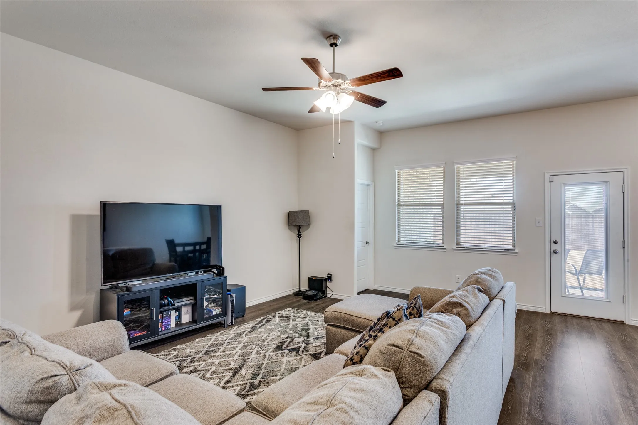 Living area with dark wood-type flooring and a ceiling fan