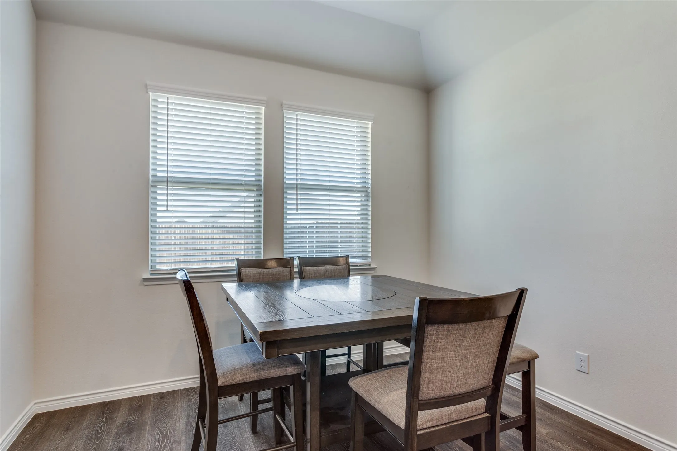Dining room featuring dark wood-style floors and baseboards