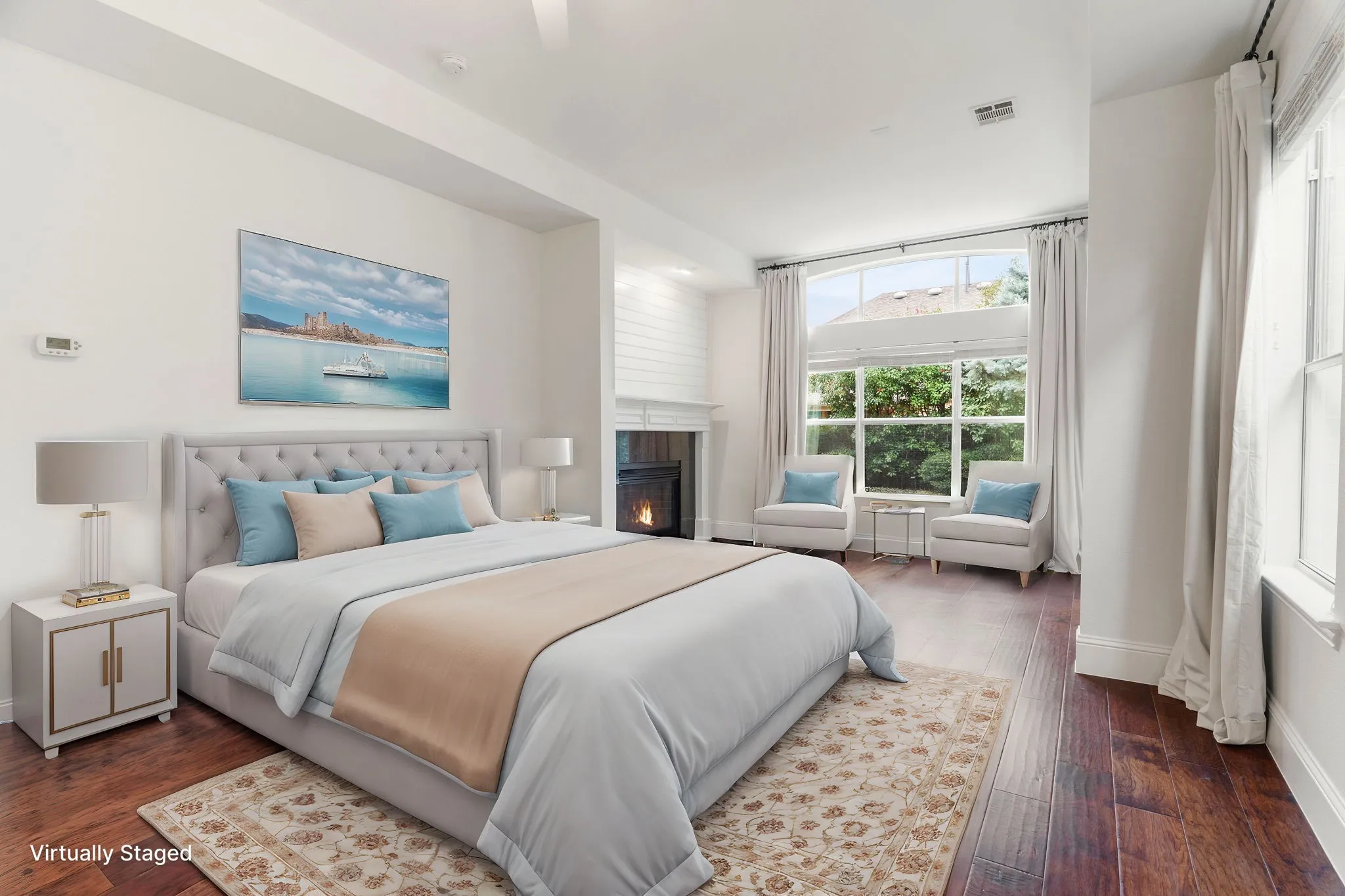 Extra large primary bedroom with sitting area in front of the fireplace.