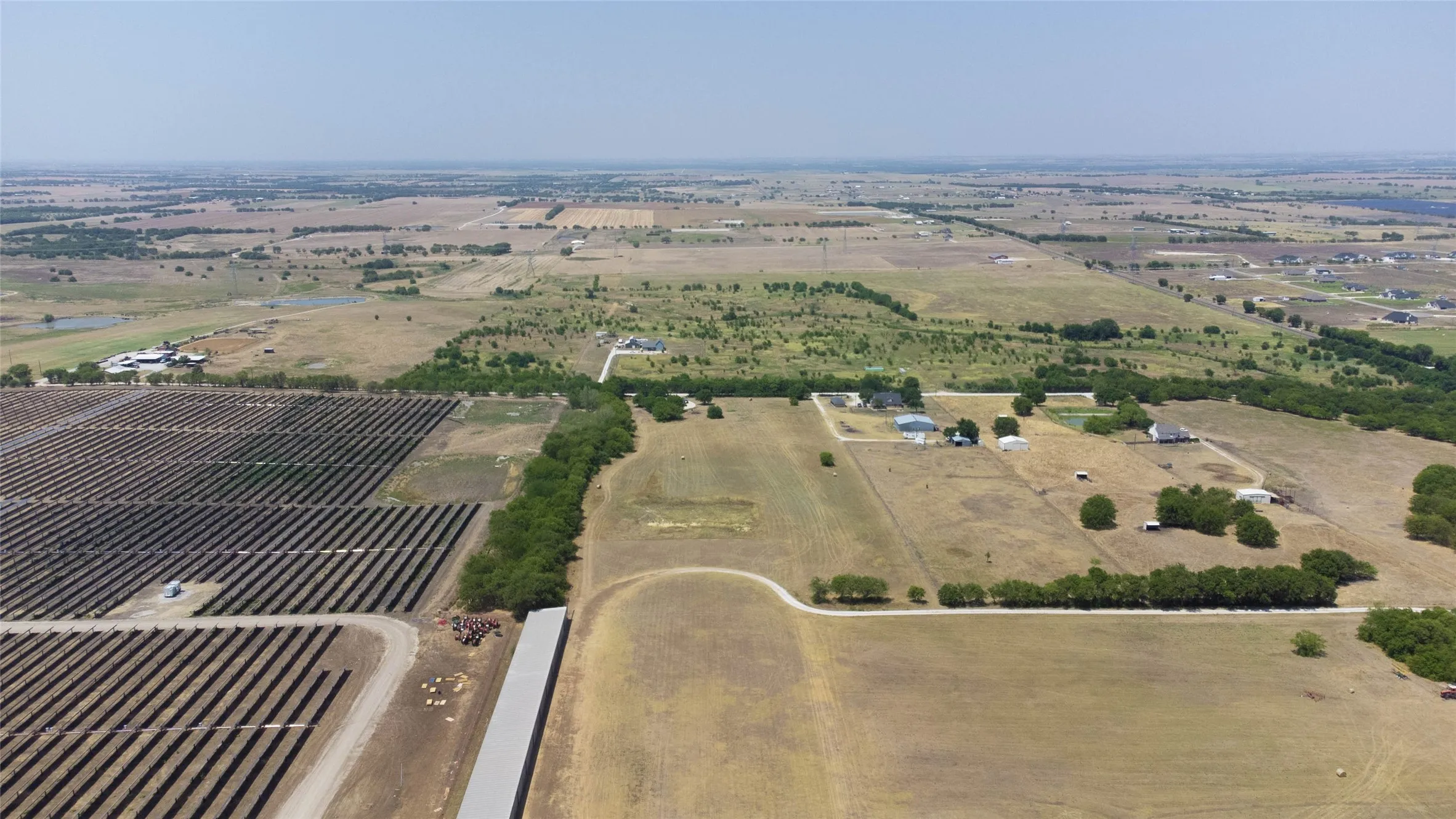 Aerial view of property and surrounding area with rural landscape and rows of crops