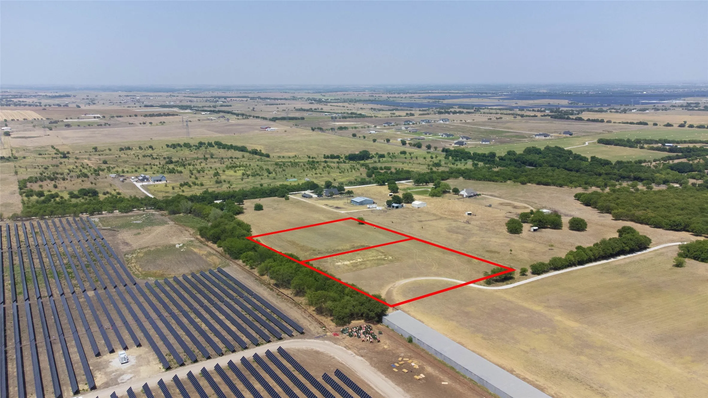 Aerial view of sparsely populated area with property boundaries highlighted and farmland