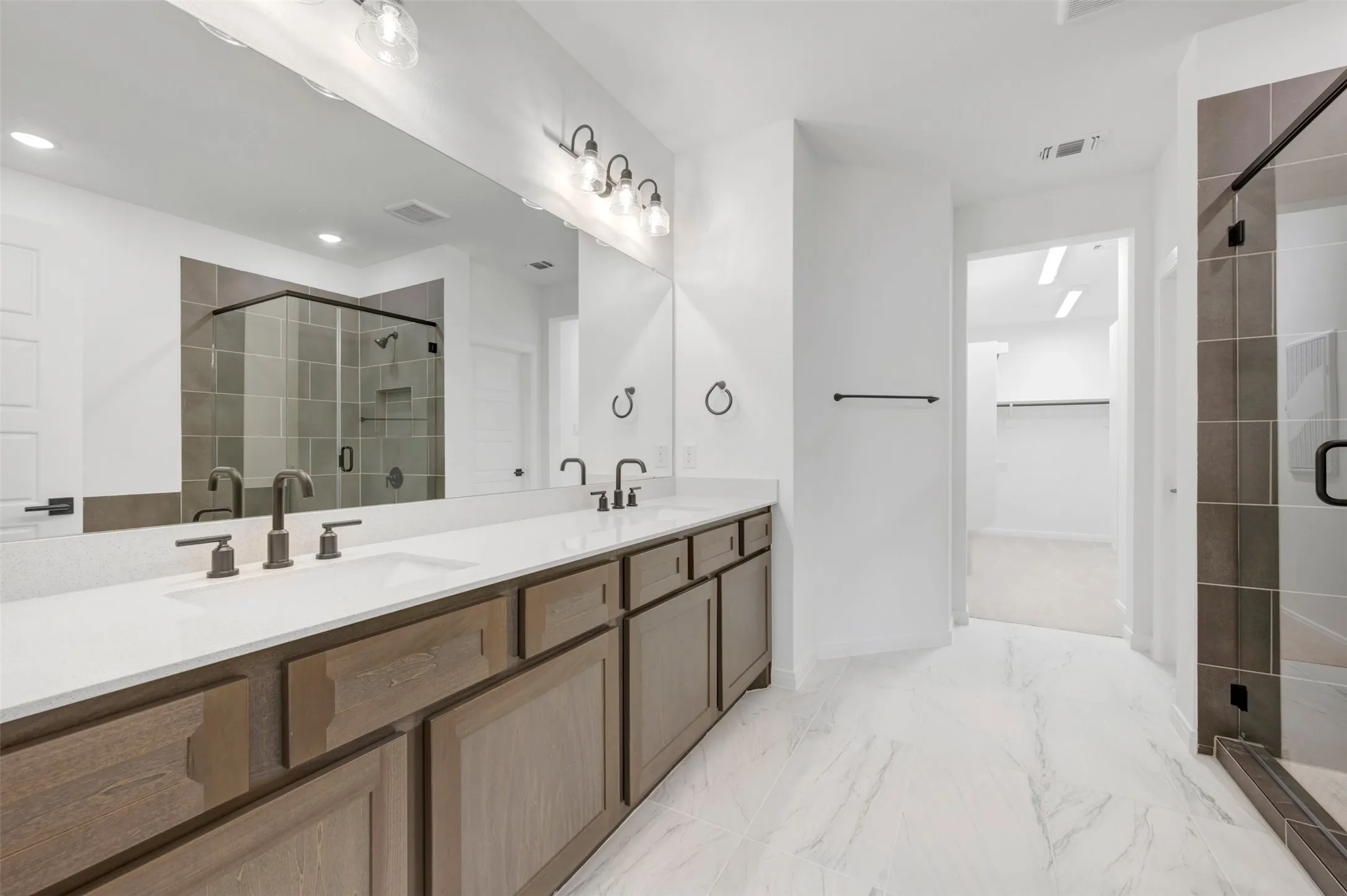 Dual vanity with white countertops, undermount sinks, and dark bronze-finish fixtures