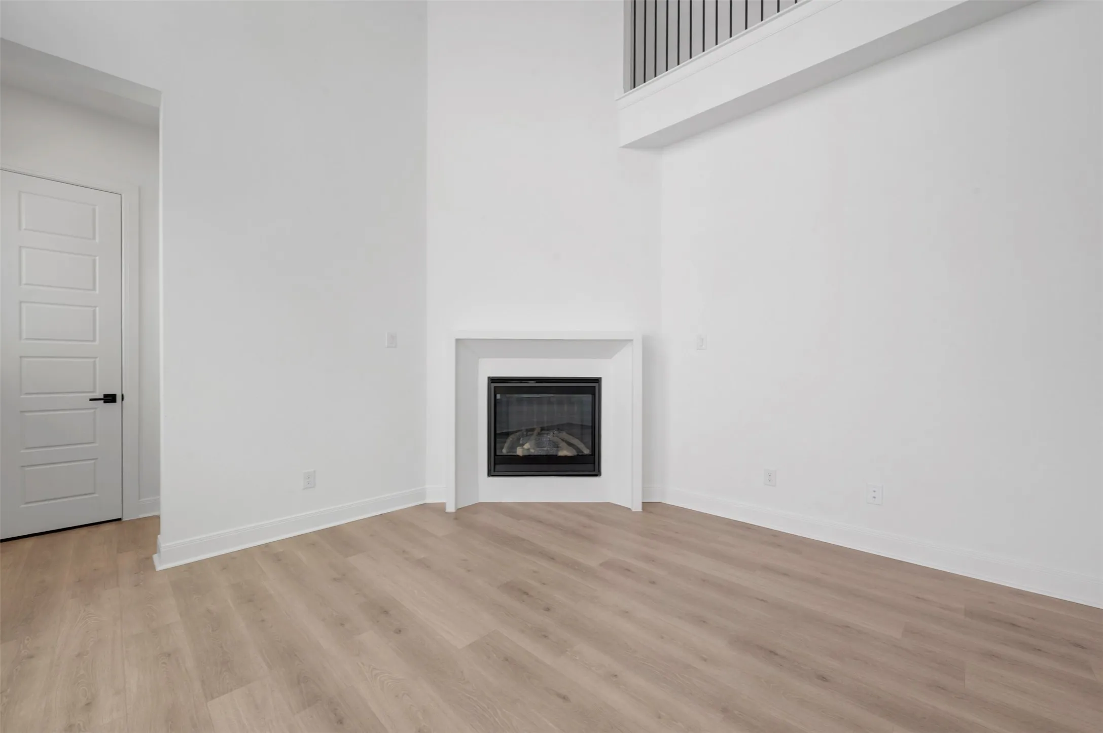 Bright, open living space showcasing wood-finish flooring, clean white walls, and abundant natural light