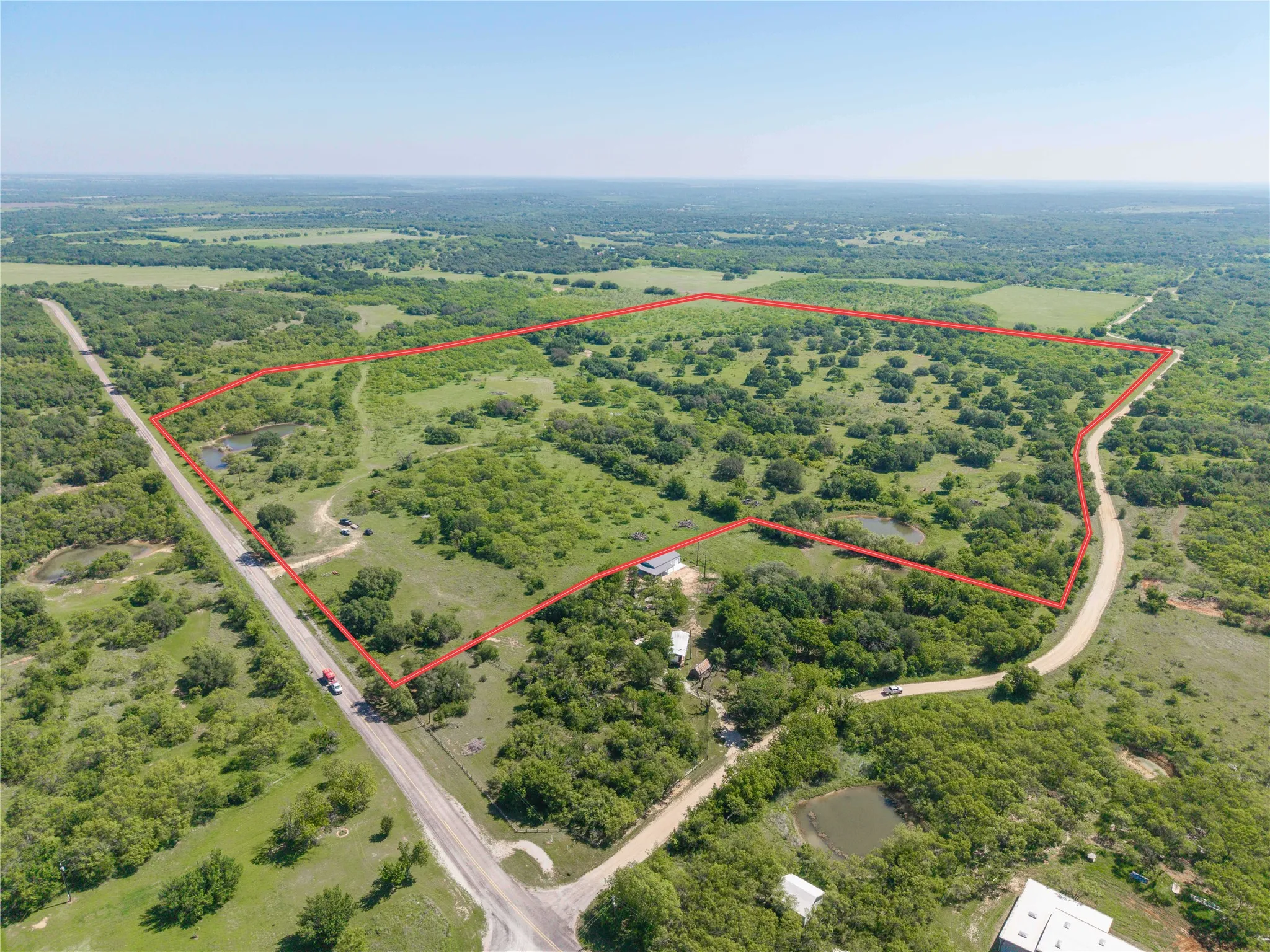 Expansive land offering diverse topography, including open clearings and wooded areas