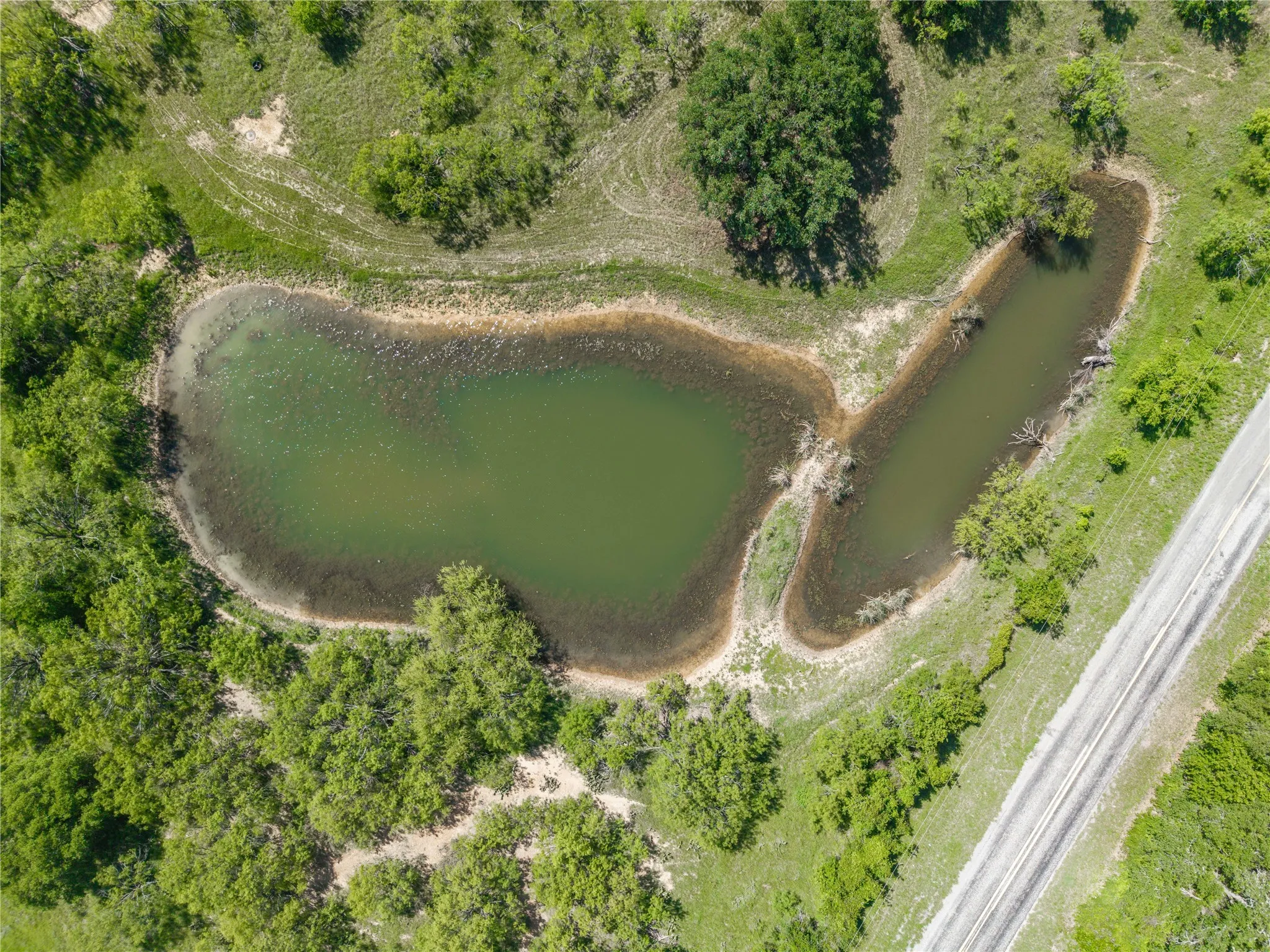 Aerial perspective showcasing two interconnected water features within a verdant landscape