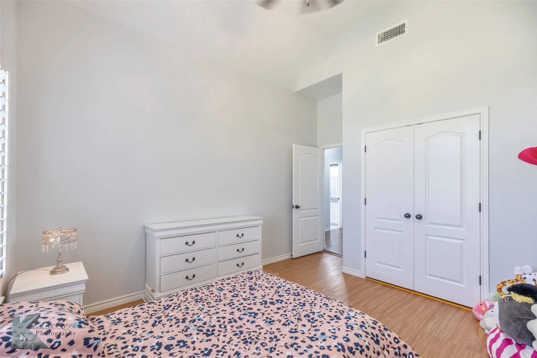 Bedroom with high vaulted ceiling, light wood-style flooring, and a closet