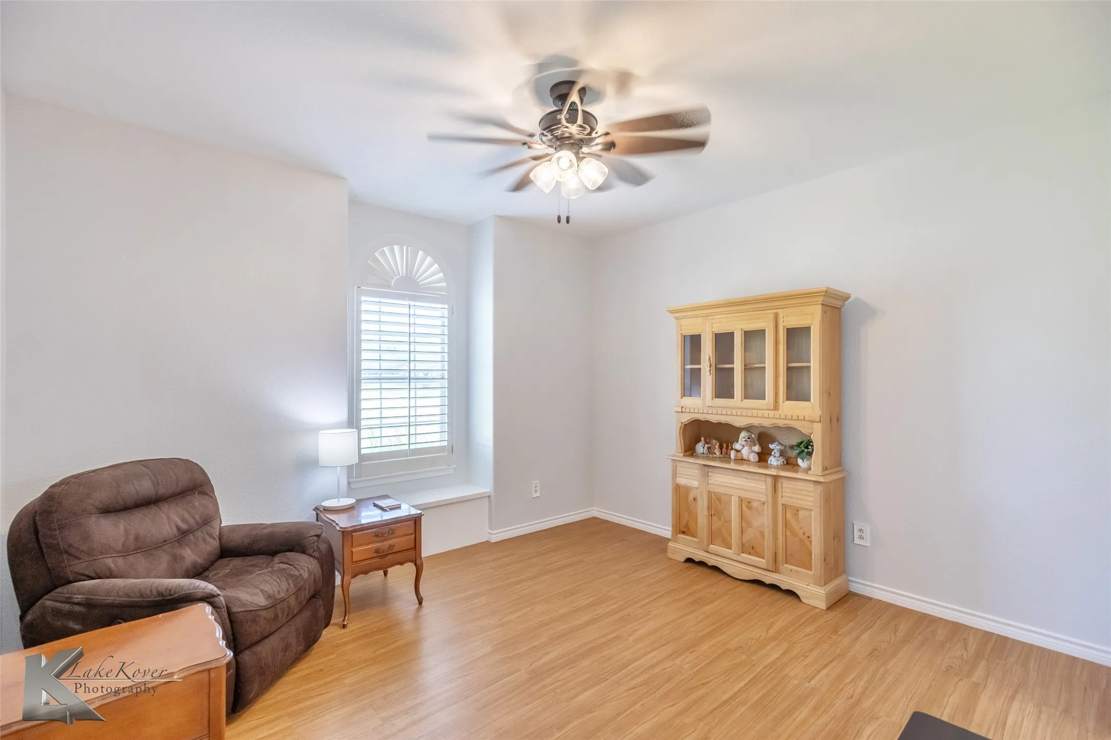 Sitting room with light wood finished floors and ceiling fan