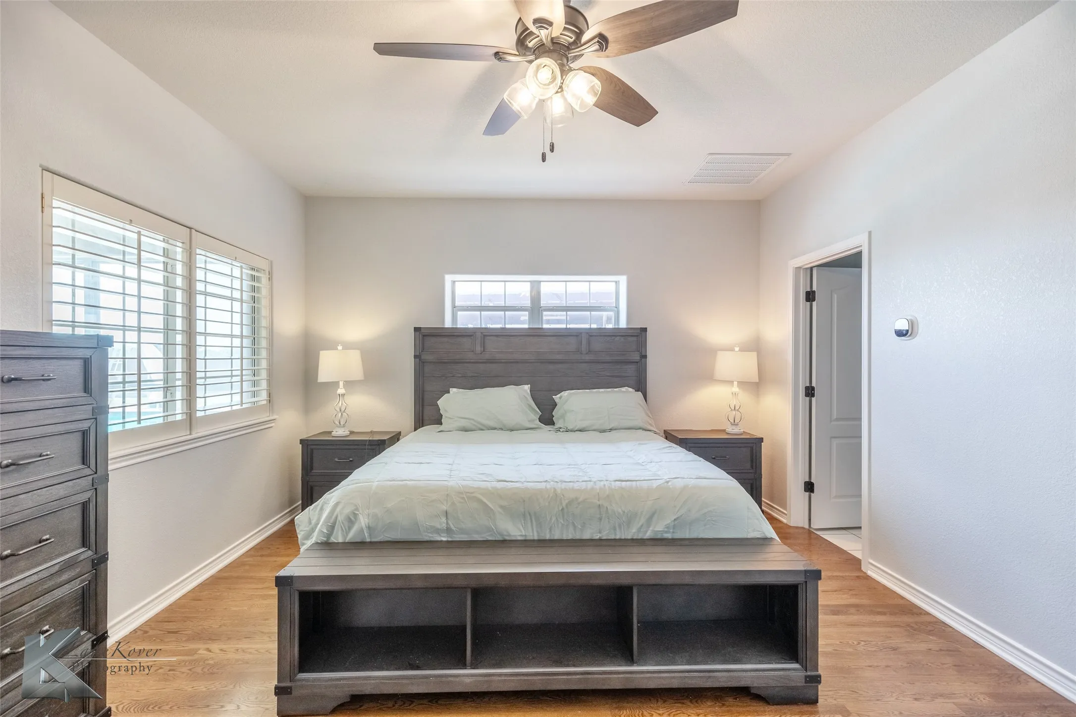Bedroom featuring multiple windows, light wood finished floors, and ceiling fan