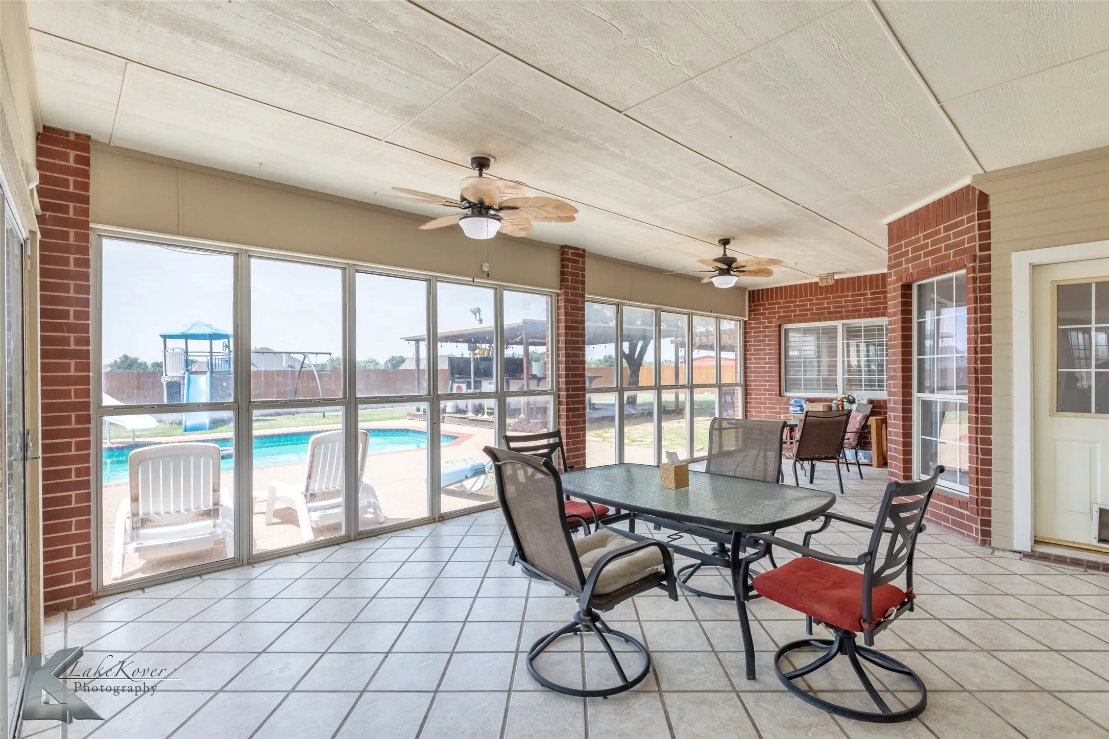 Sunroom / solarium with a ceiling fan and outdoor dining space