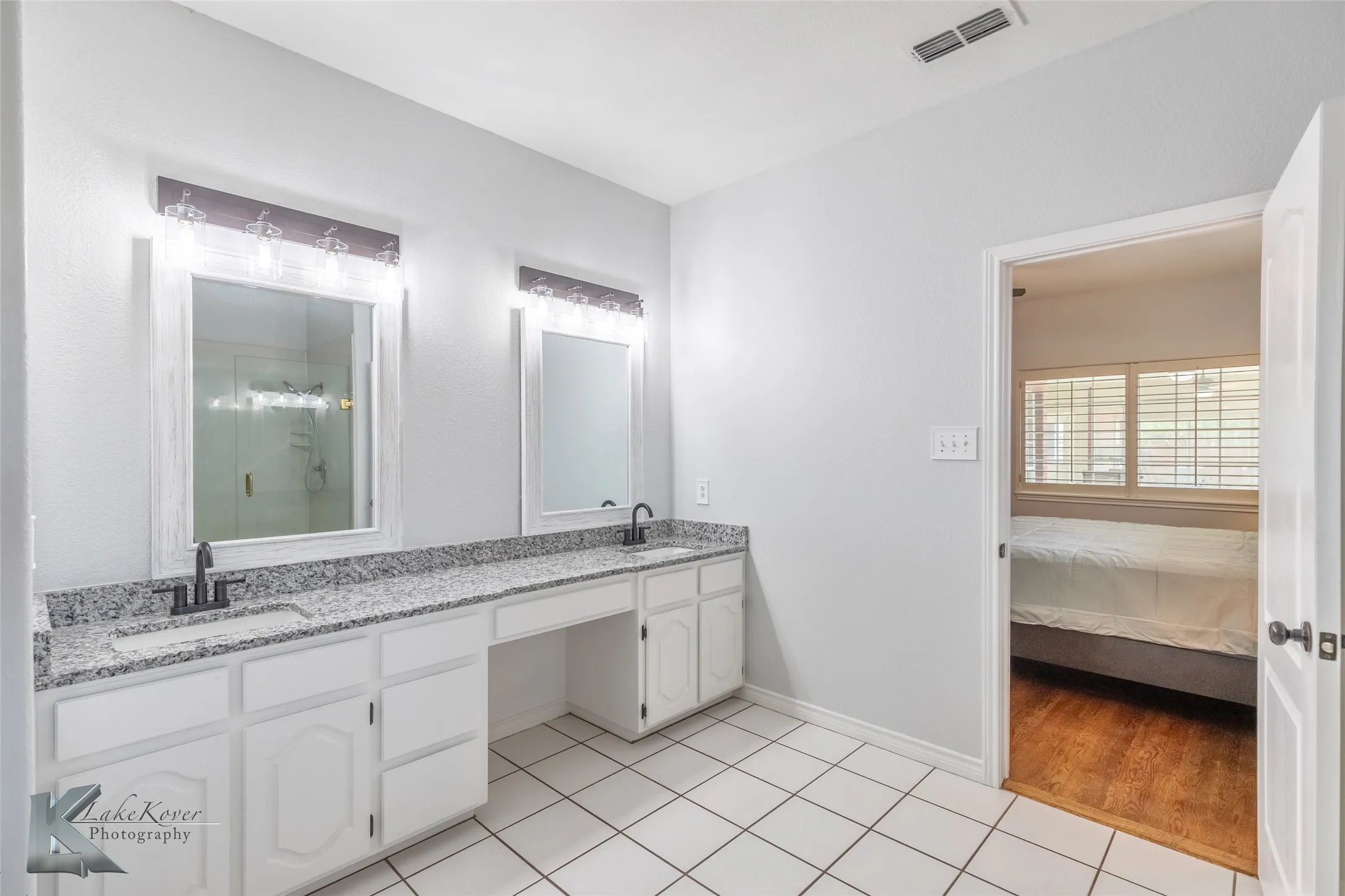 Full bathroom with double vanity, a shower stall, tile patterned flooring, and ensuite bathroom