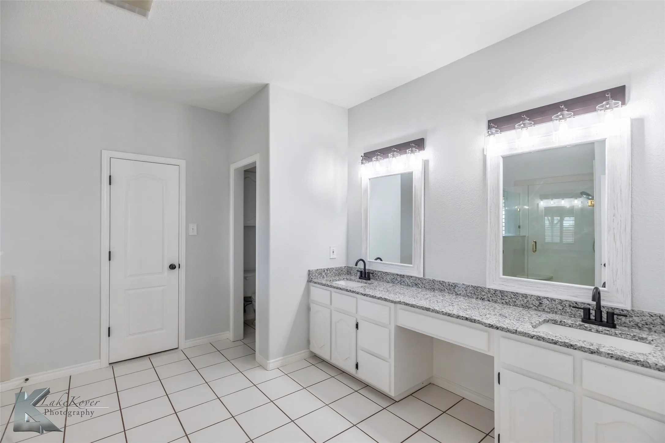 Full bath with double vanity, a stall shower, and tile patterned floors
