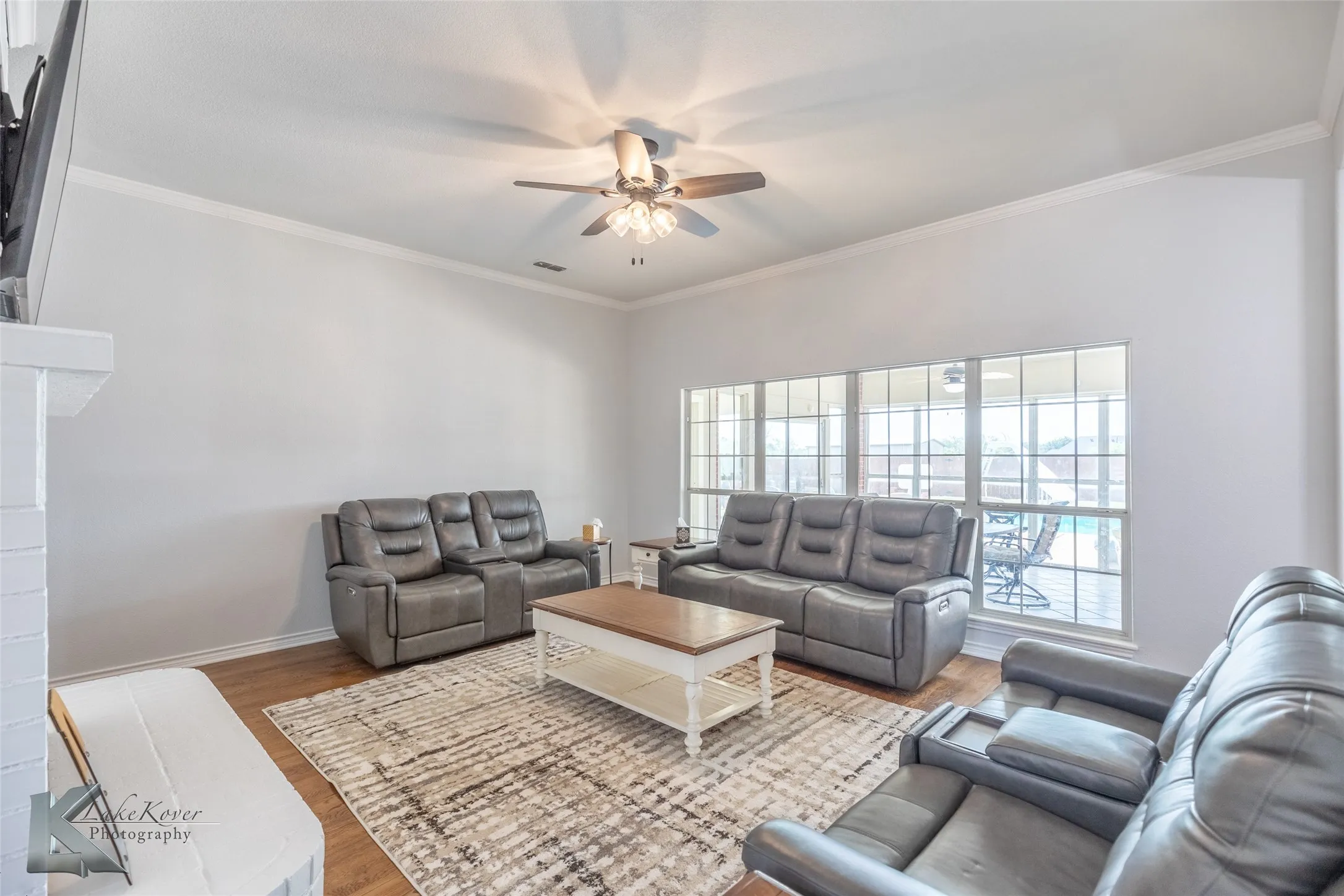Living area featuring a ceiling fan, wood finished floors, and ornamental molding