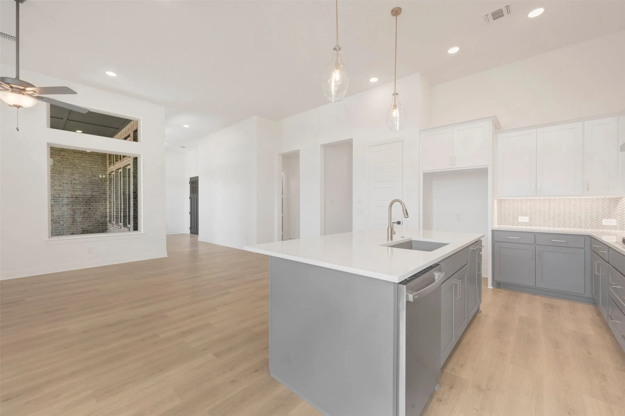 Contemporary kitchen island with a built-in sink, stainless steel faucet, and dishwasher