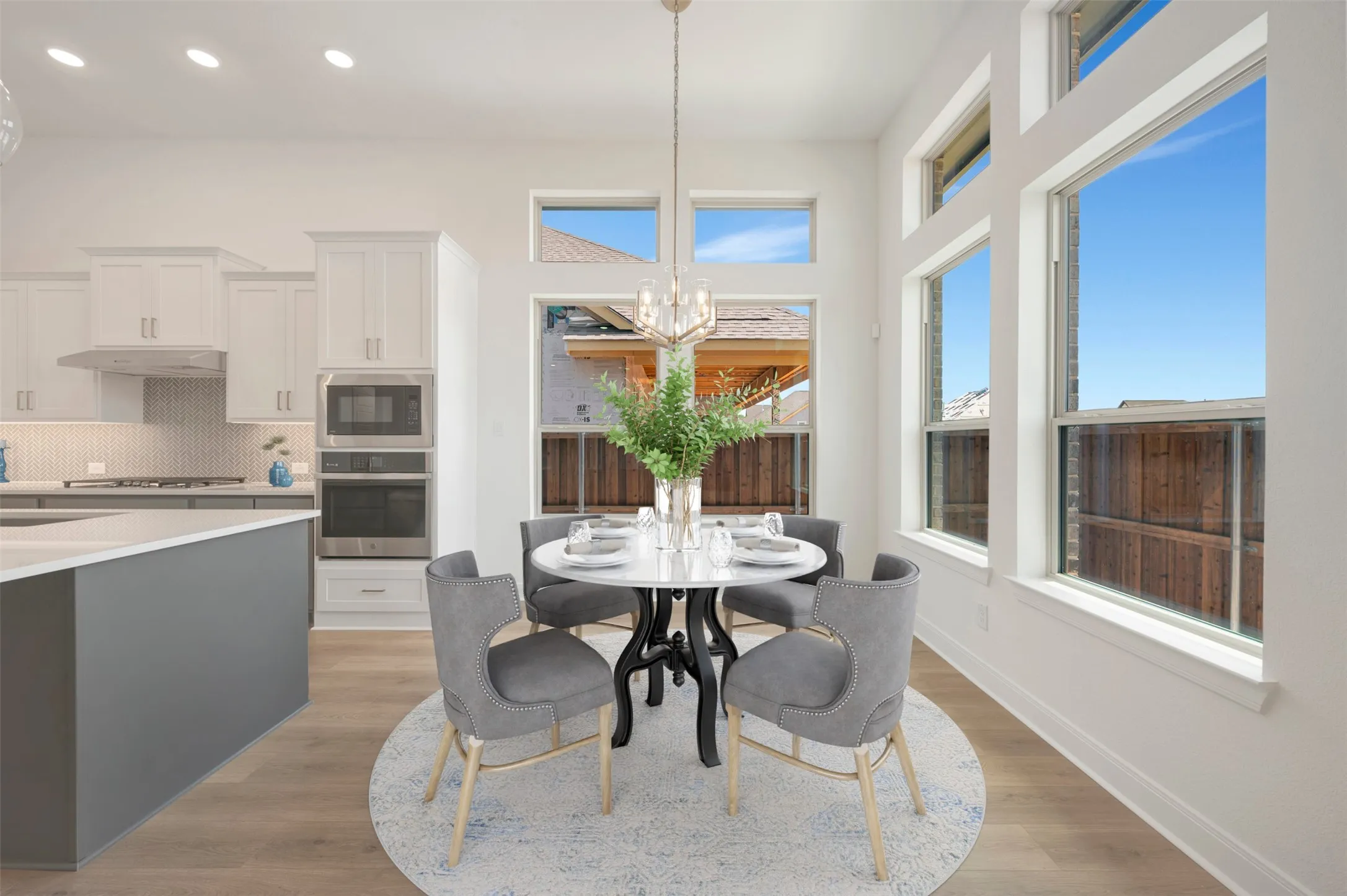 Open-concept dining area featuring soaring ceilings and abundant natural light from multiple windows