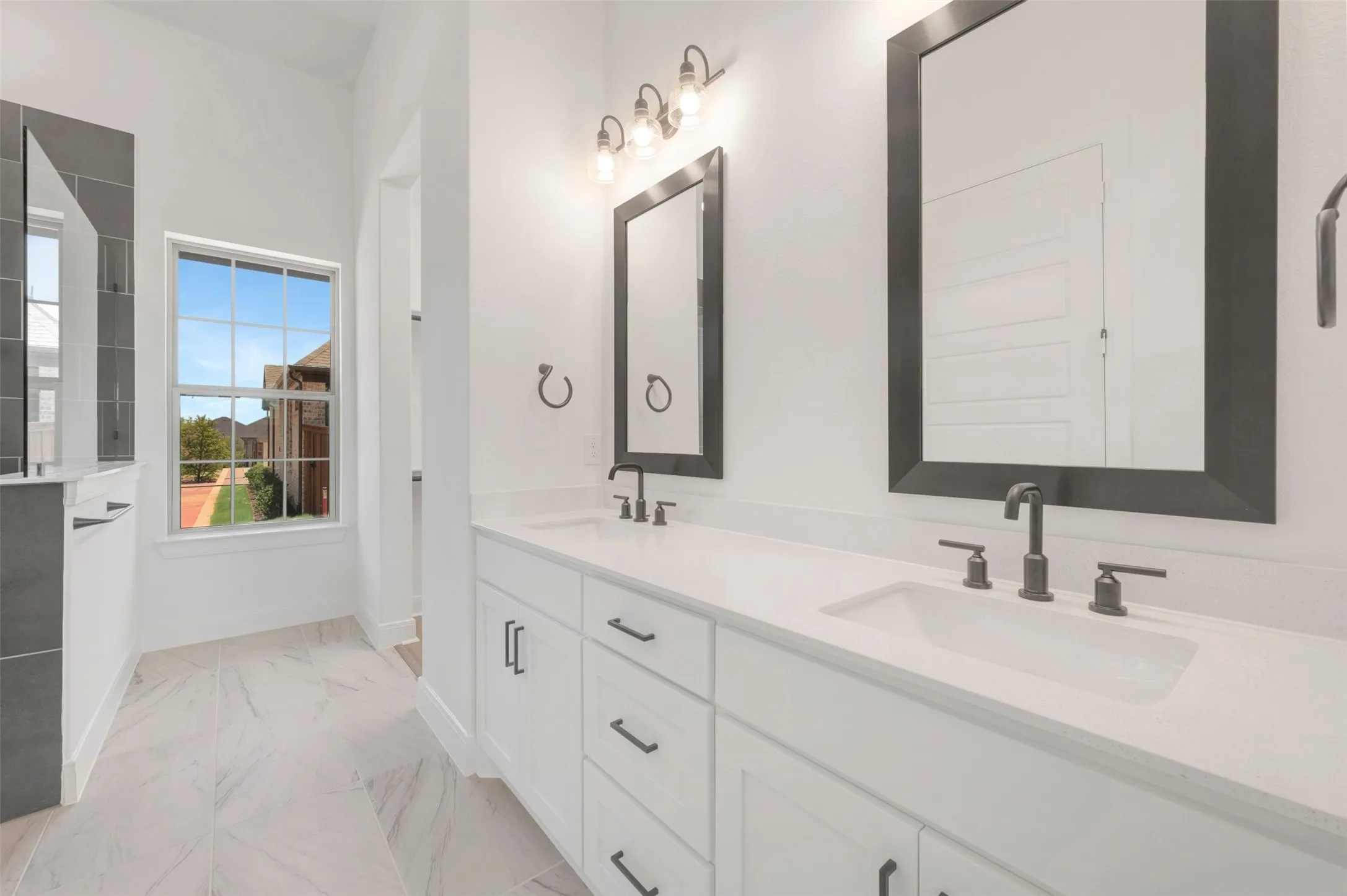 Dual vanity with white cabinetry, quartz-finish countertops, undermount sinks, and matte black fixtures