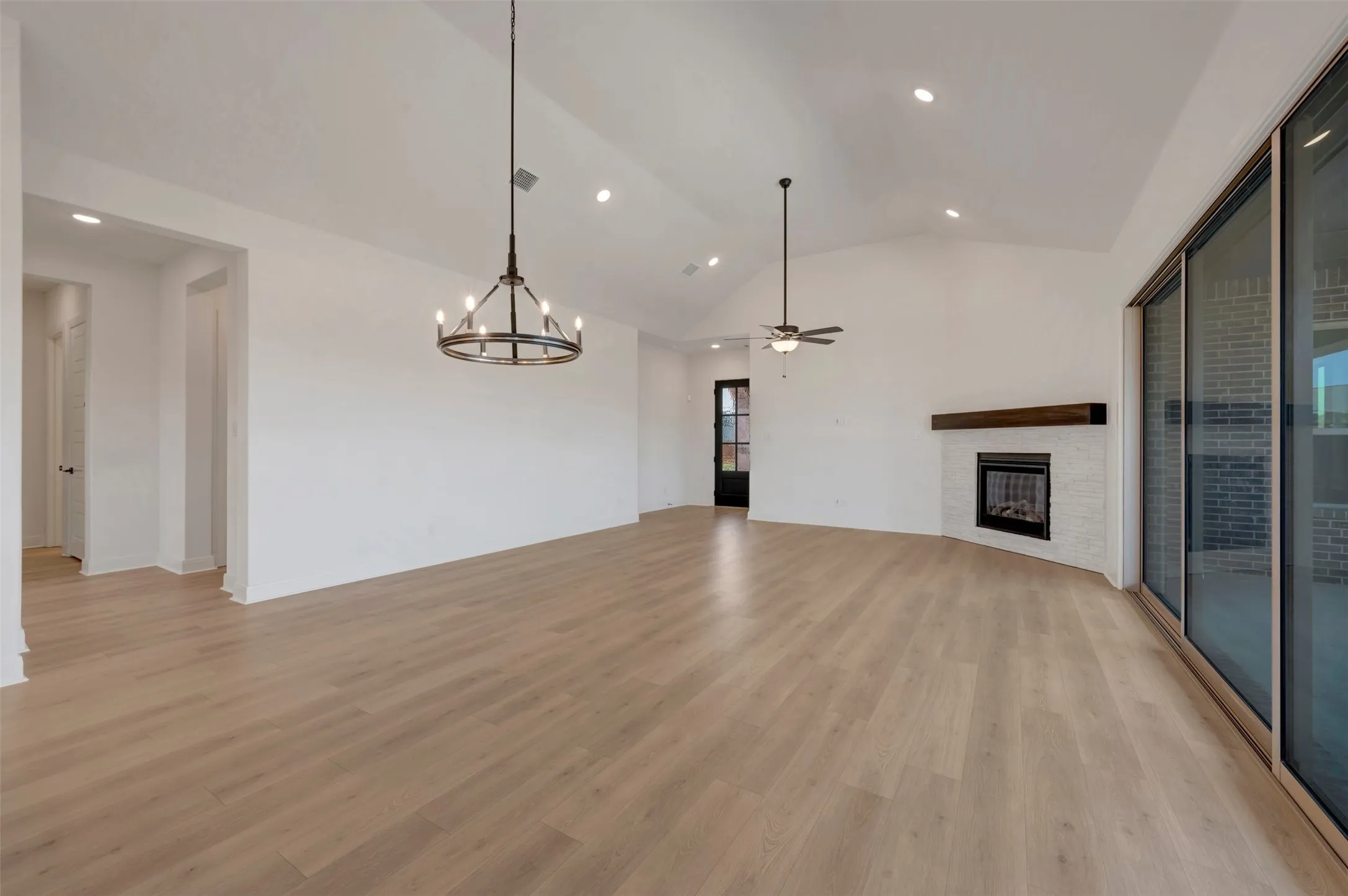 Spacious interior featuring wood-finish flooring, vaulted ceilings, and recessed lighting