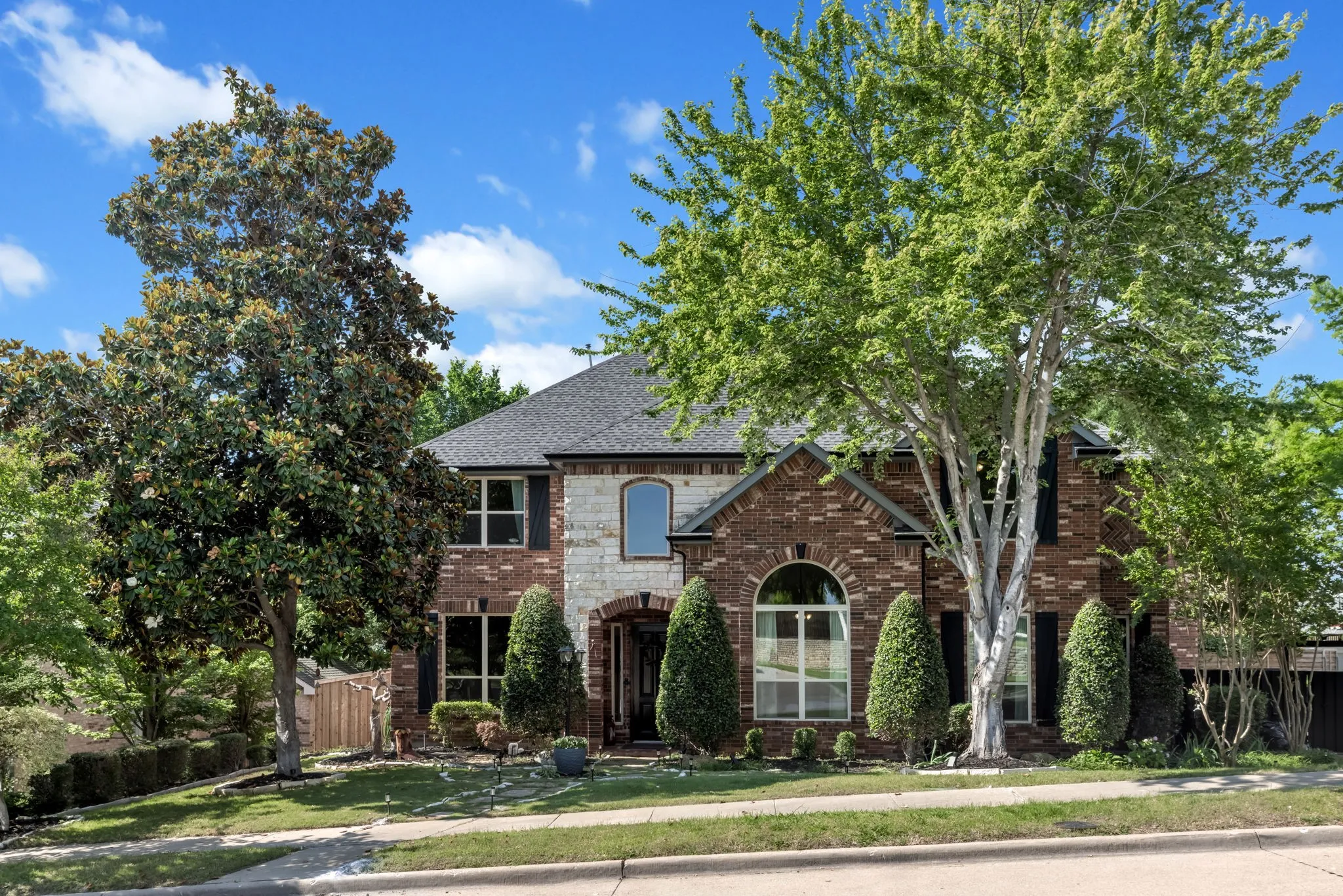 Two-story home featuring a brick and stone facade
