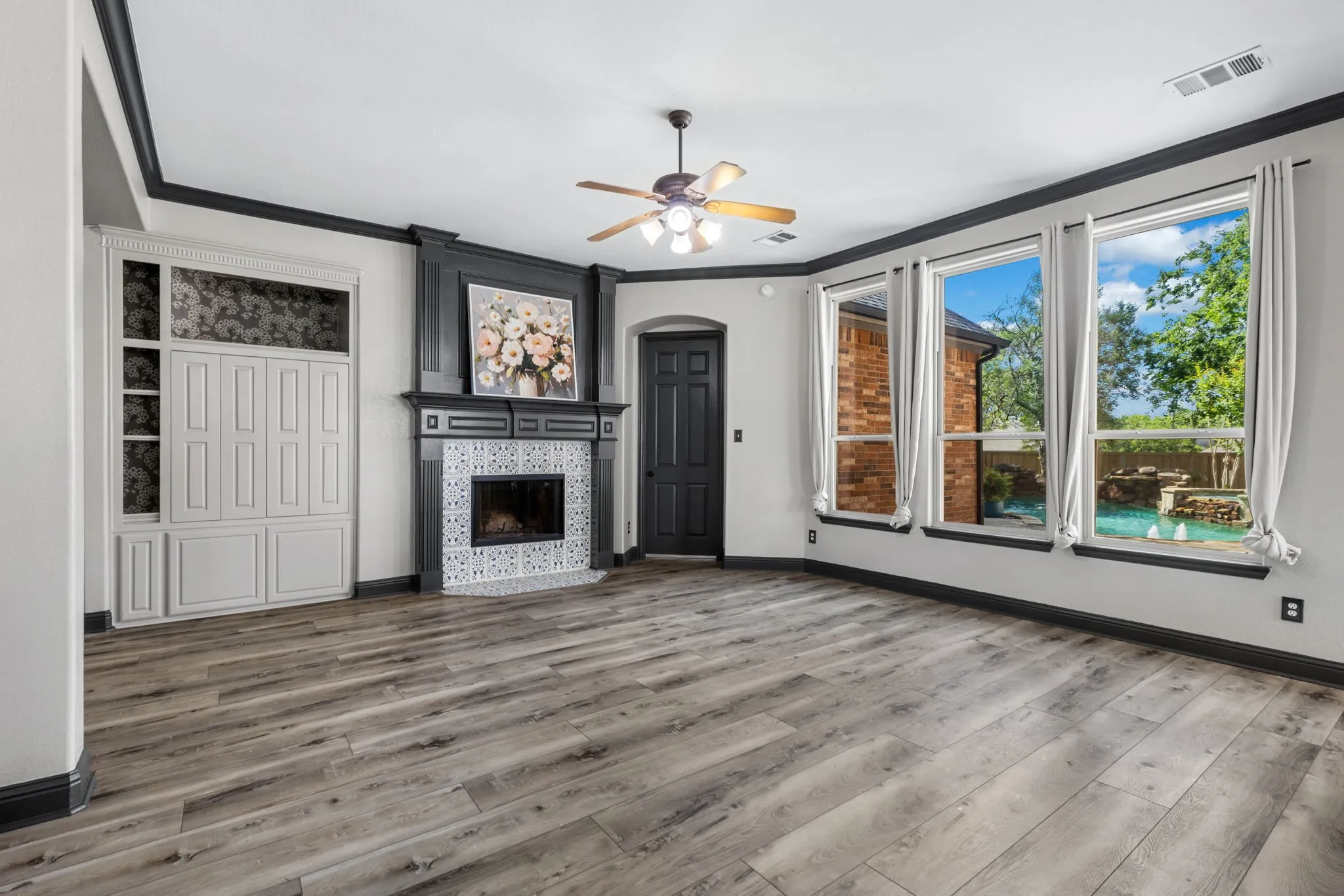 Living area featuring wood-finish flooring and a ceiling fan with integrated lighting