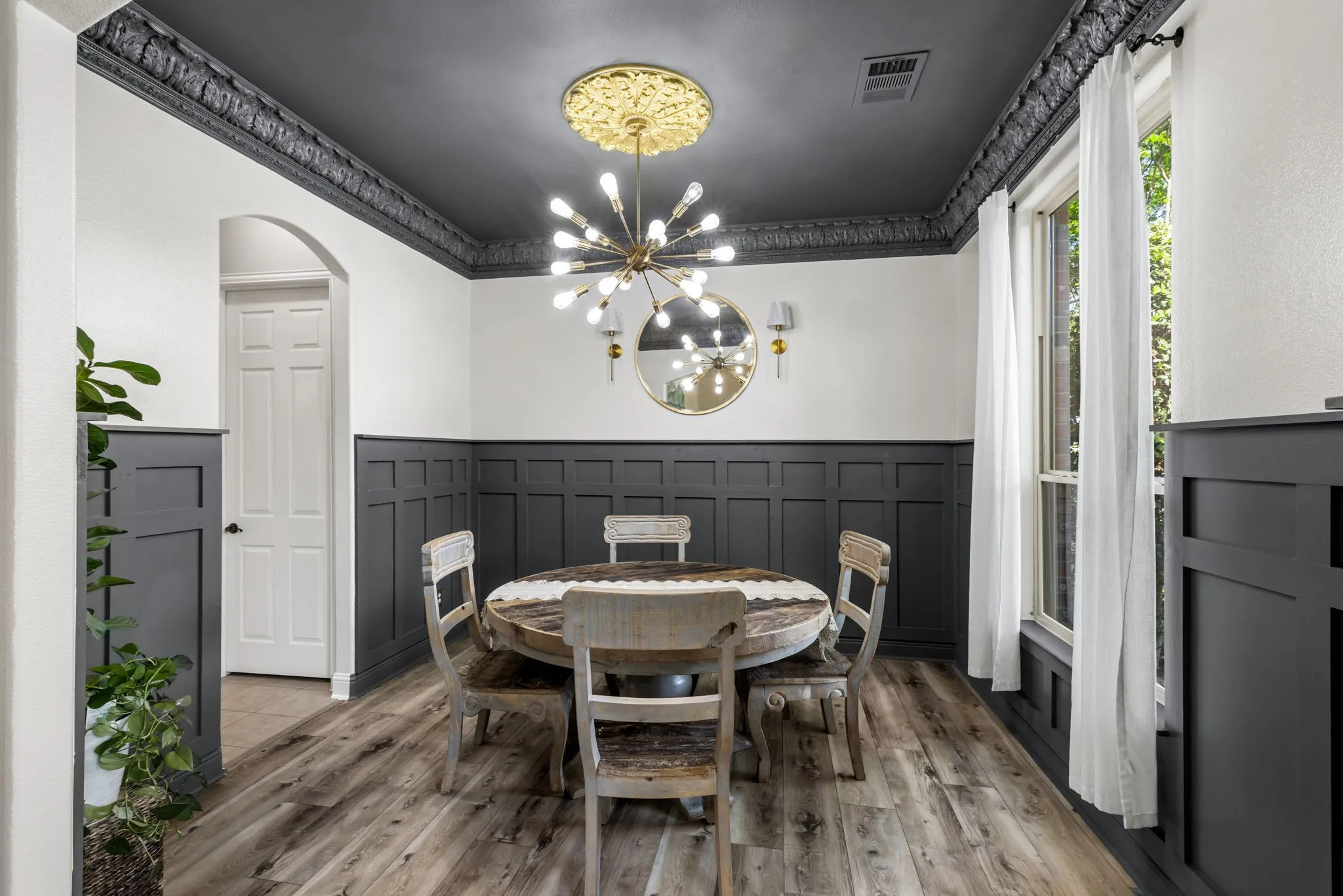 Dining area featuring wood-finish flooring, wainscoting, and large windows