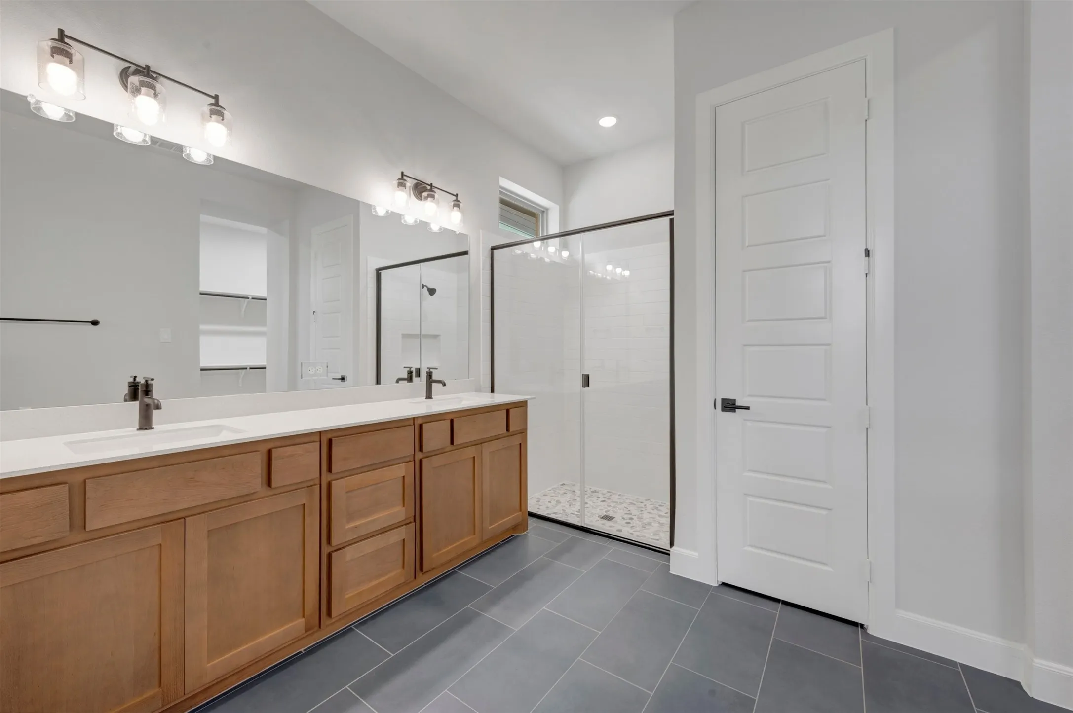 Dual vanity with wood-finish cabinetry and white countertops