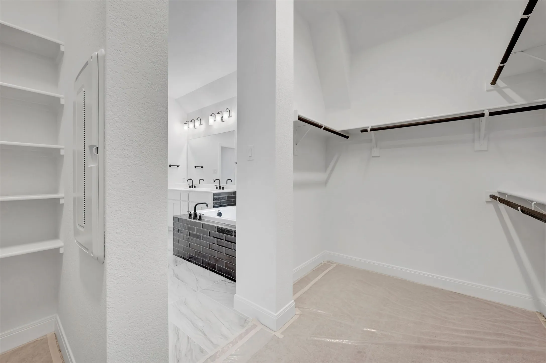 Walk-in closet with multiple hanging rods and shelving