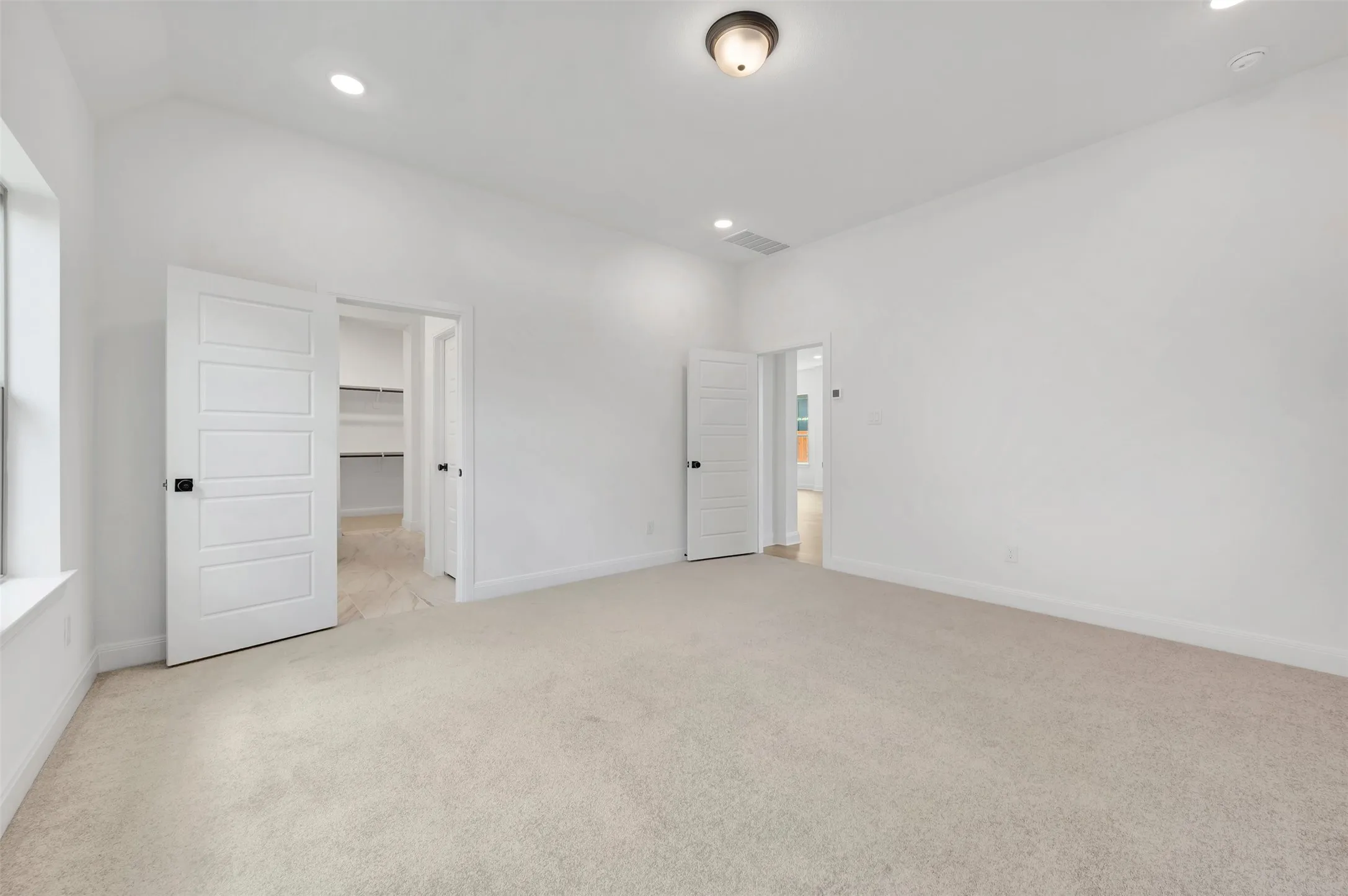 Spacious room featuring neutral carpeting and white walls
