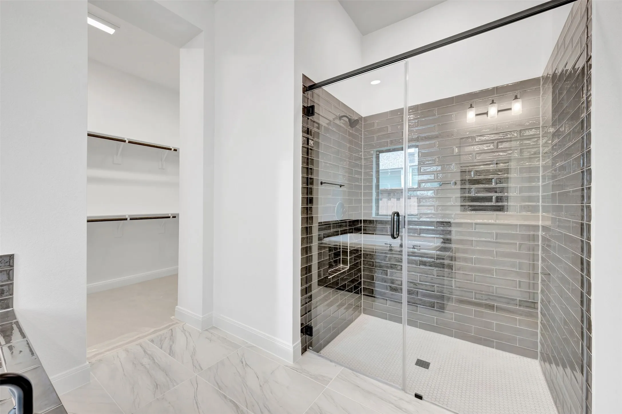 Walk-in shower featuring subway tile surround, integrated bench, and mosaic tile floor