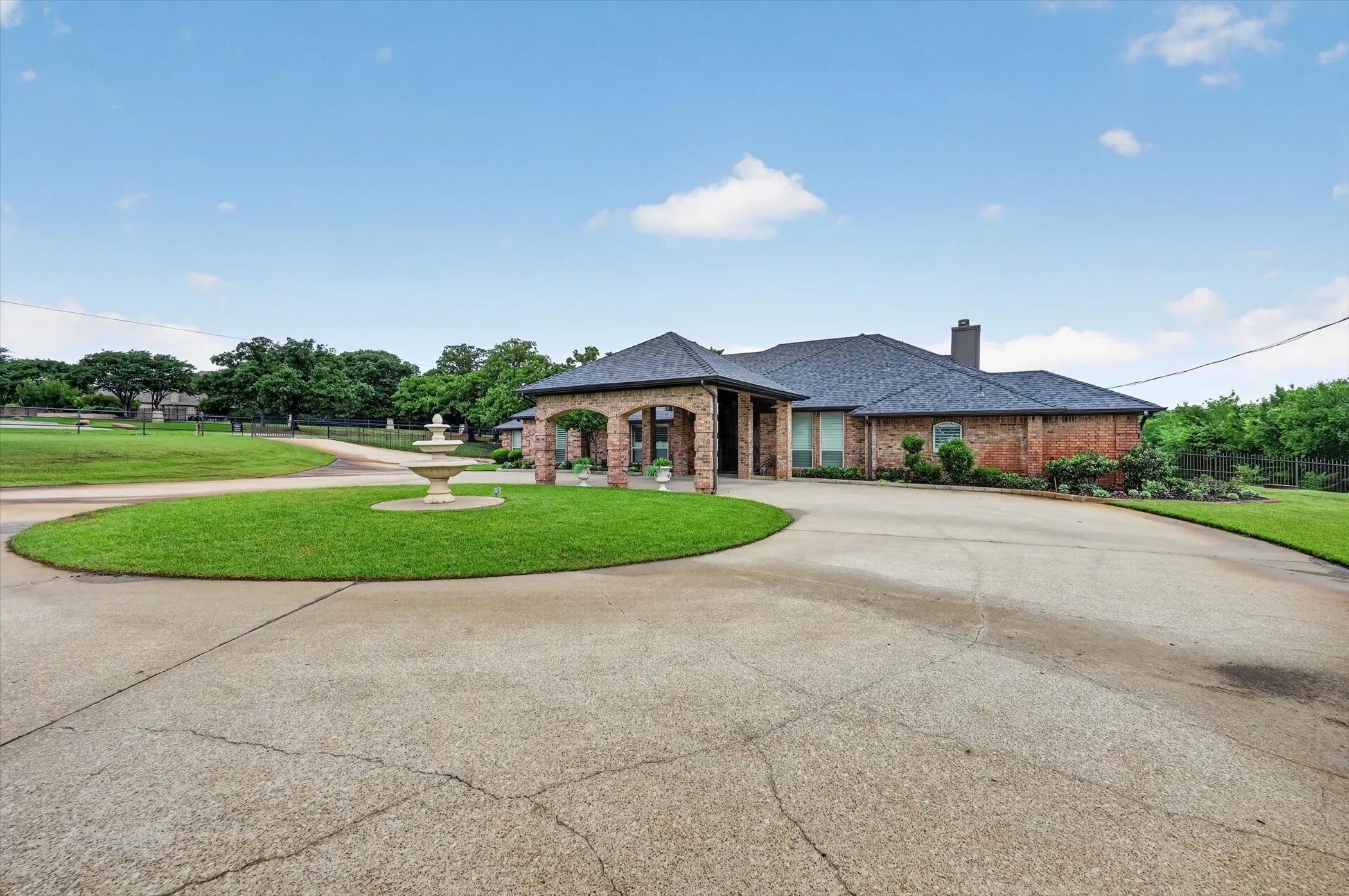 Brick exterior residence with a dark shingle roof and a covered entry
