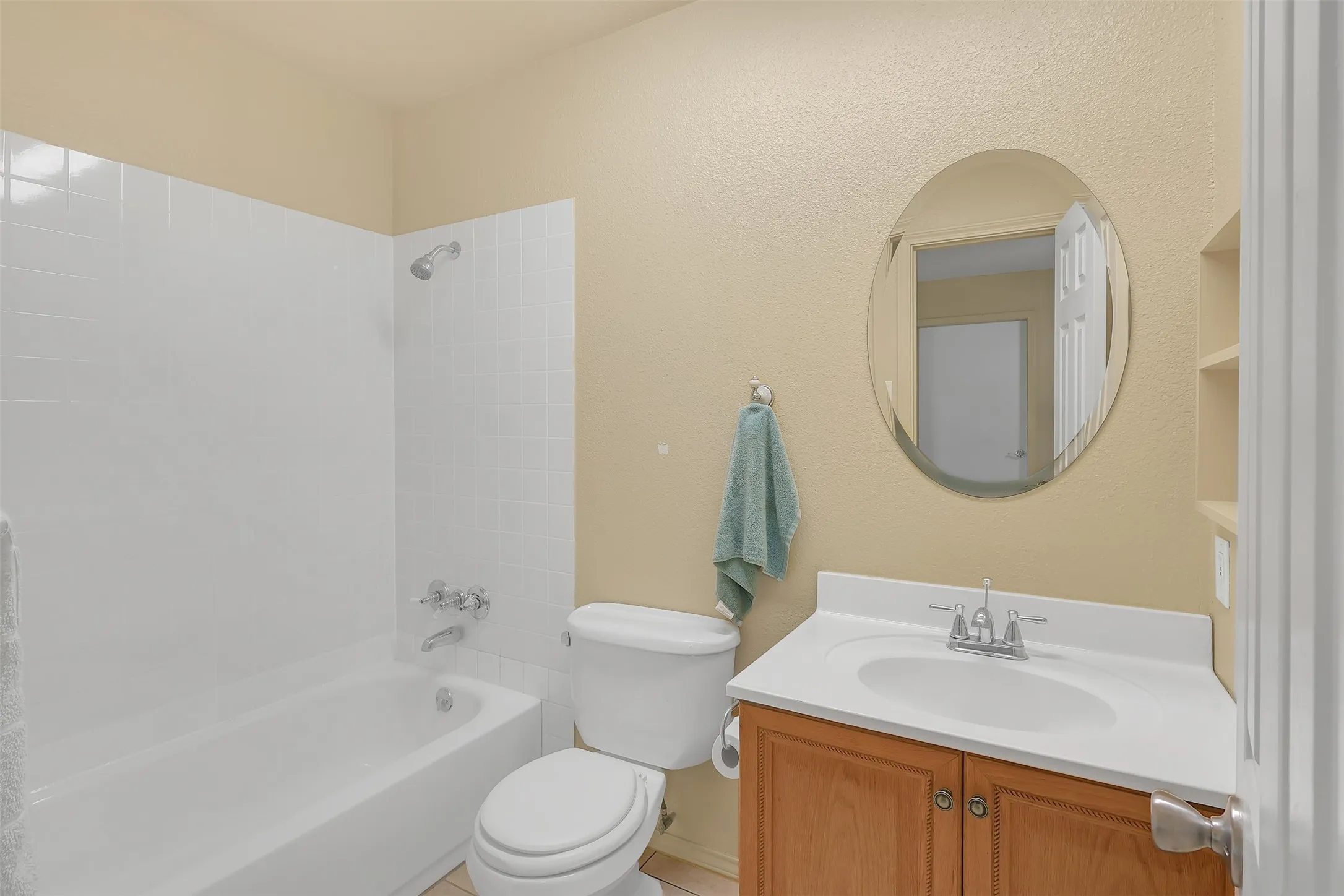 Bathroom with vanity, shower / washtub combination, and a textured wall