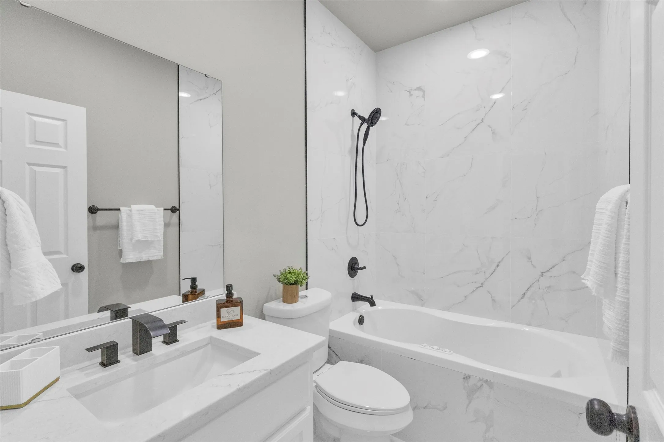 Full bathroom with vanity and a combined bath / shower with marble appearance
