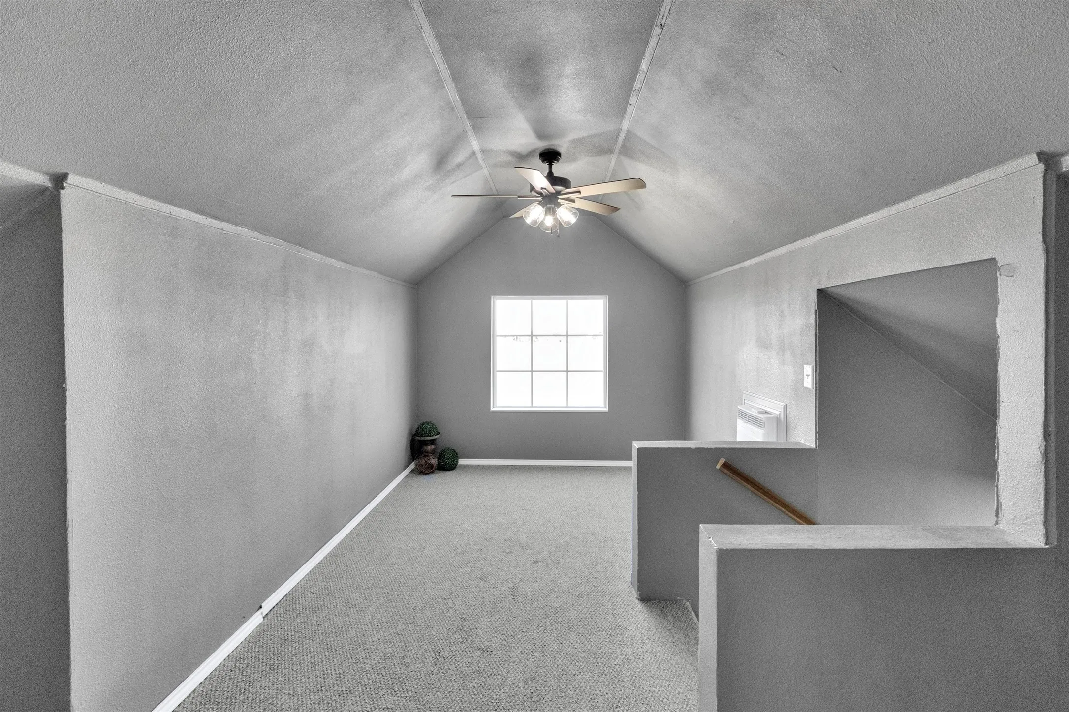 Bonus room featuring light carpet, a textured ceiling, a ceiling fan, and a textured wall