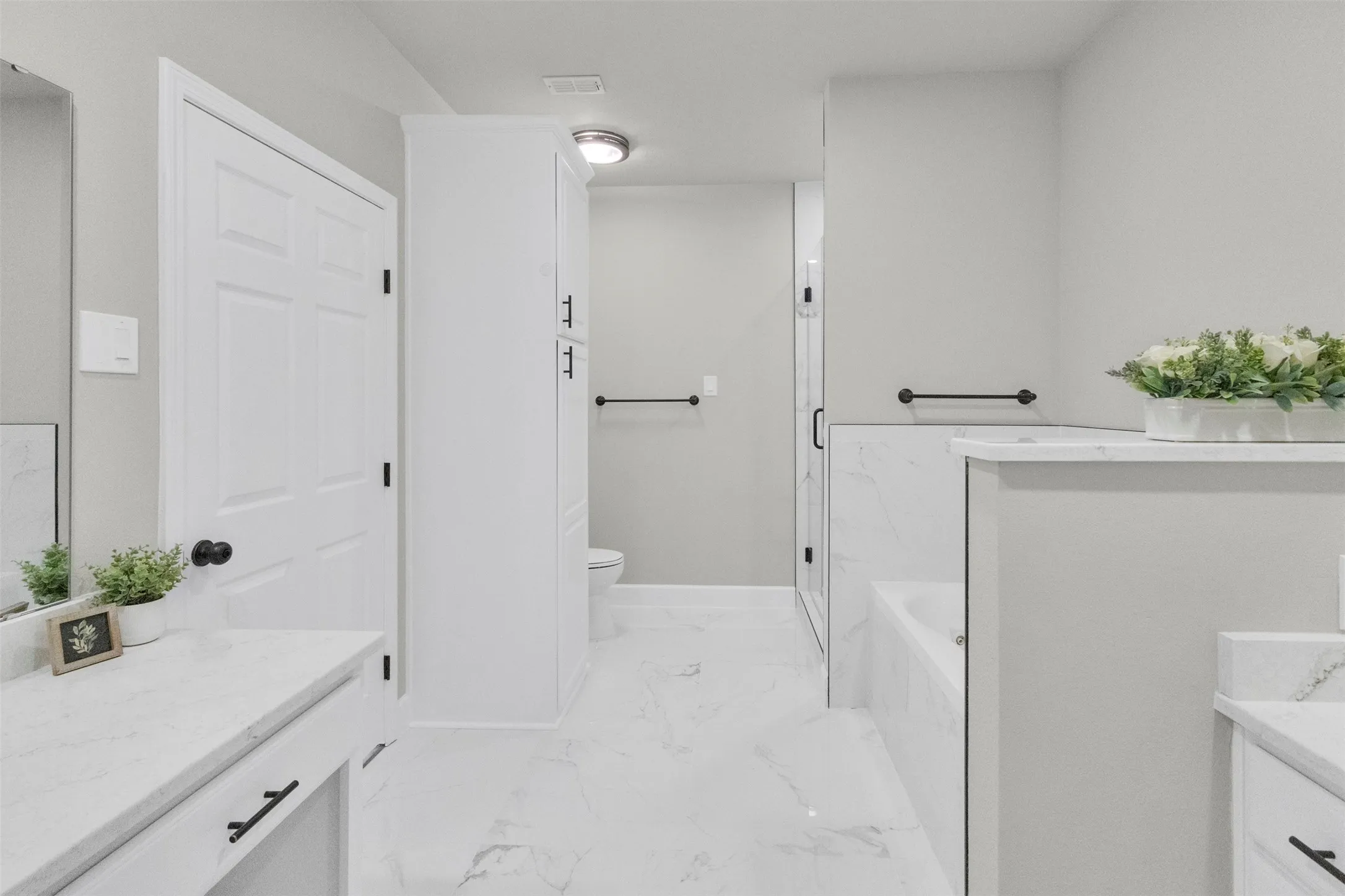 Bathroom featuring vanity, a bath, and a marble finish shower
