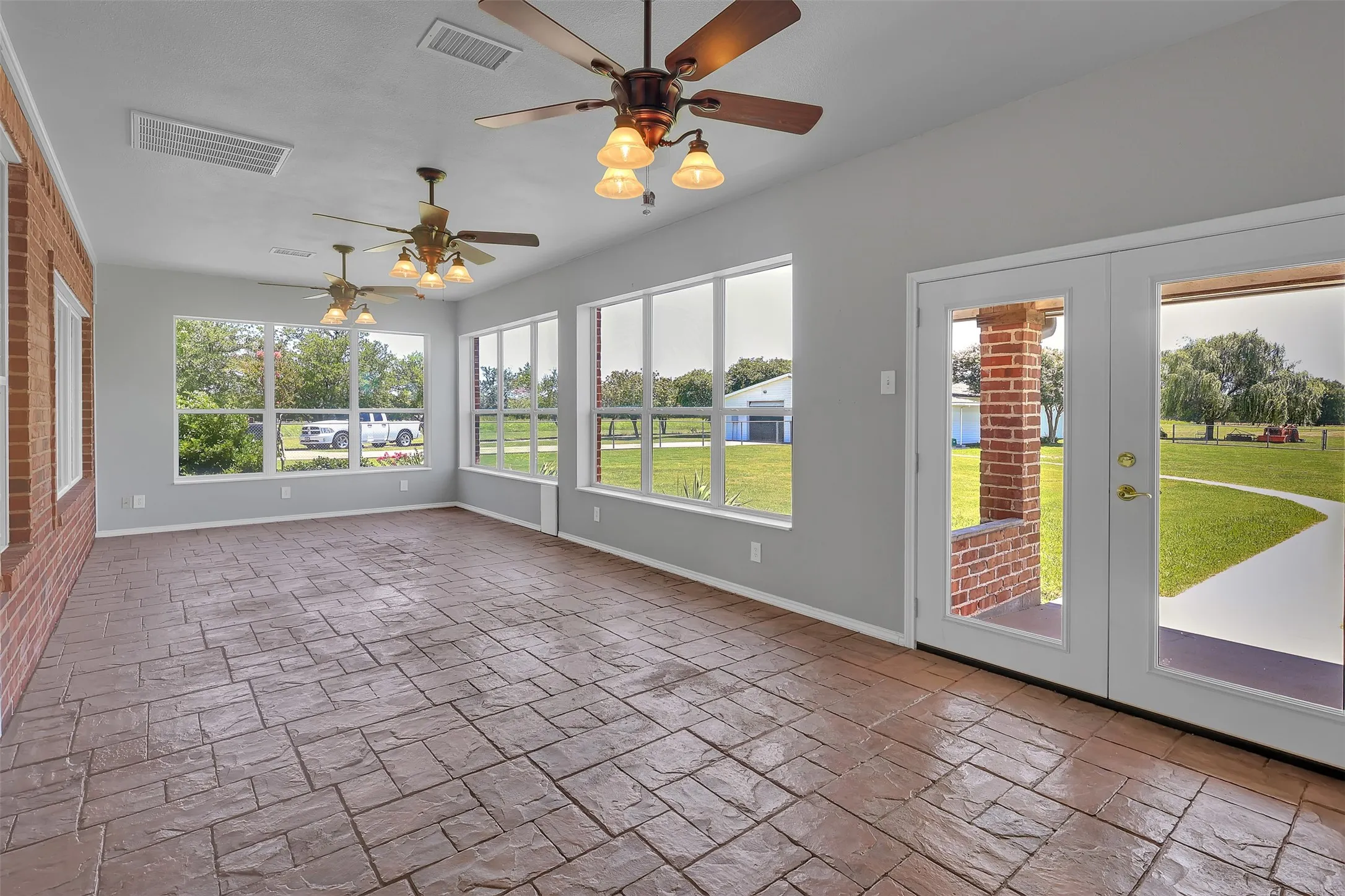 Unfurnished sunroom featuring french doors and ceiling fan